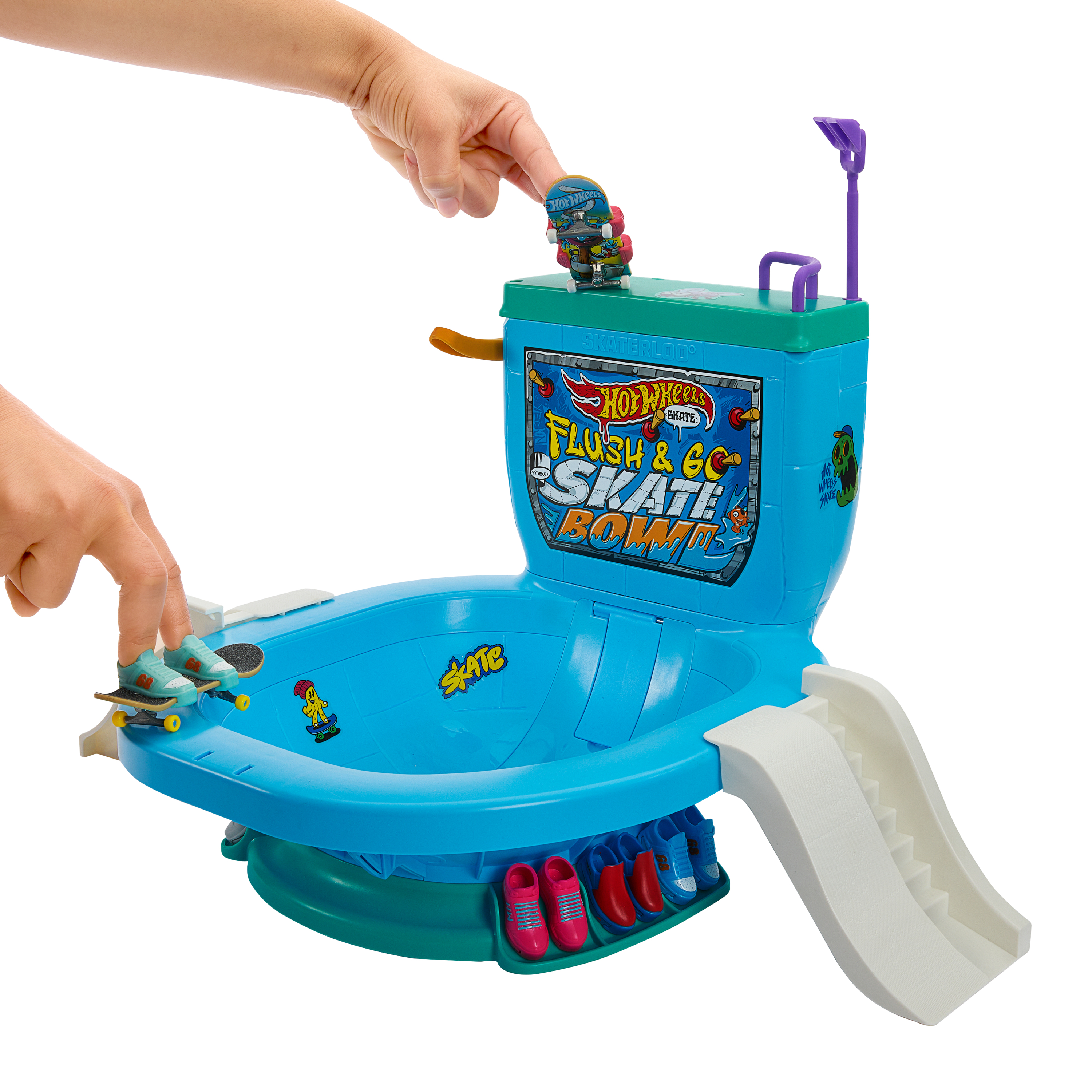 Een speelgoedtoilet met een skateboardhelling. Handen houden skateboards op het toilet. Het speelgoed is blauw en groen.