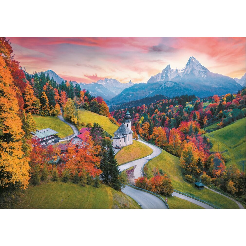 Paysage d'automne avec église, routes sinueuses, arbres colorés et montagnes sous ciel rose.