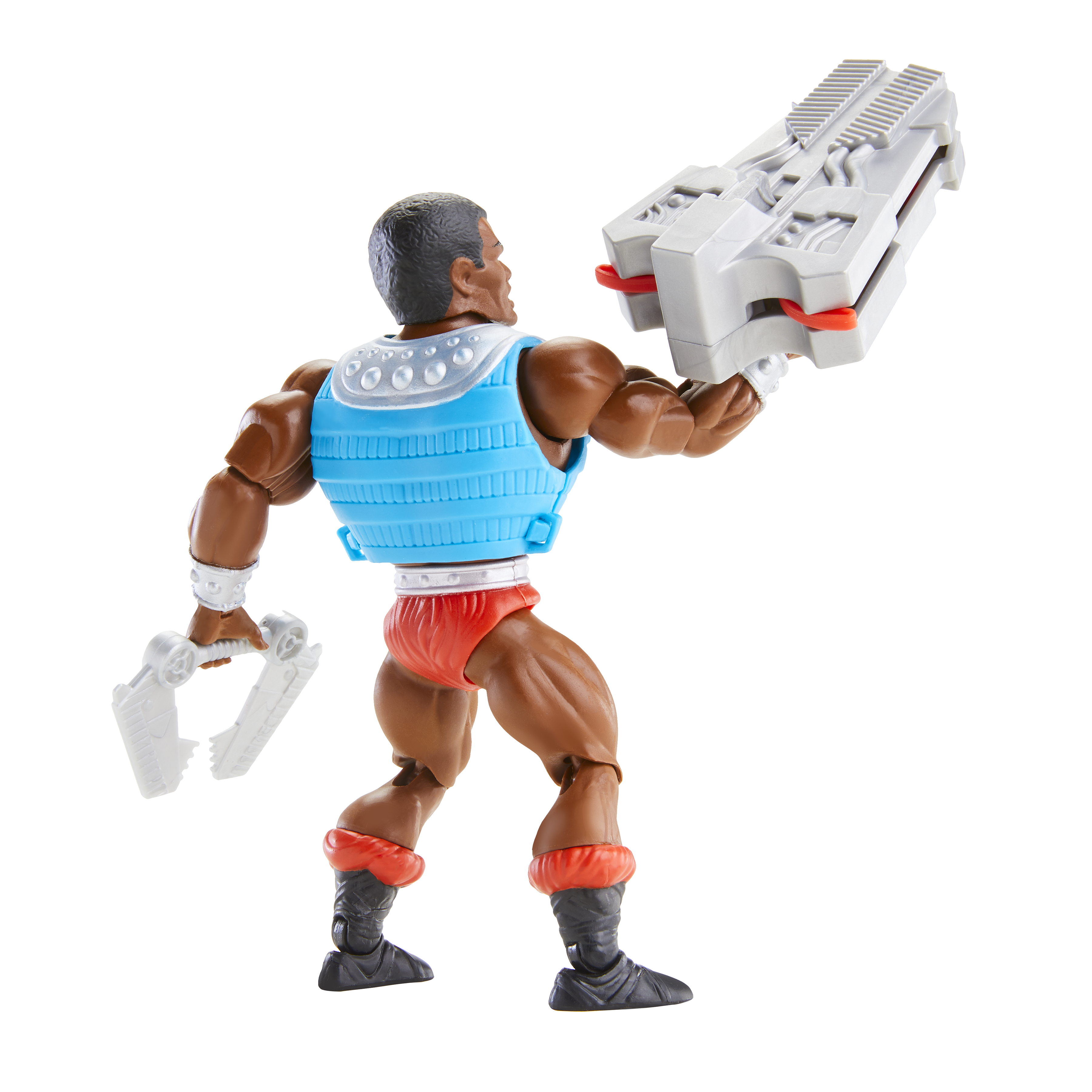Eine He-Man-Actionfigur mit blauer Weste, roten Shorts und zwei weißen Waffen vor hellem Hintergrund.