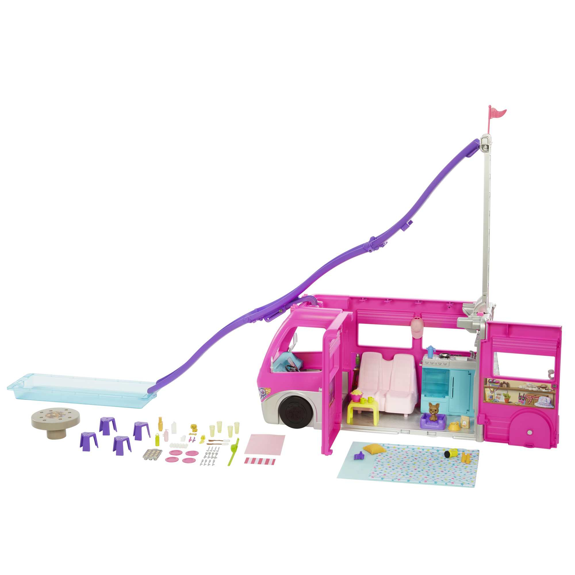 Camper giocattolo rosa con porte aperte, accessori come sedie, tavolo e piscina. Include una bandiera e uno scivolo viola.