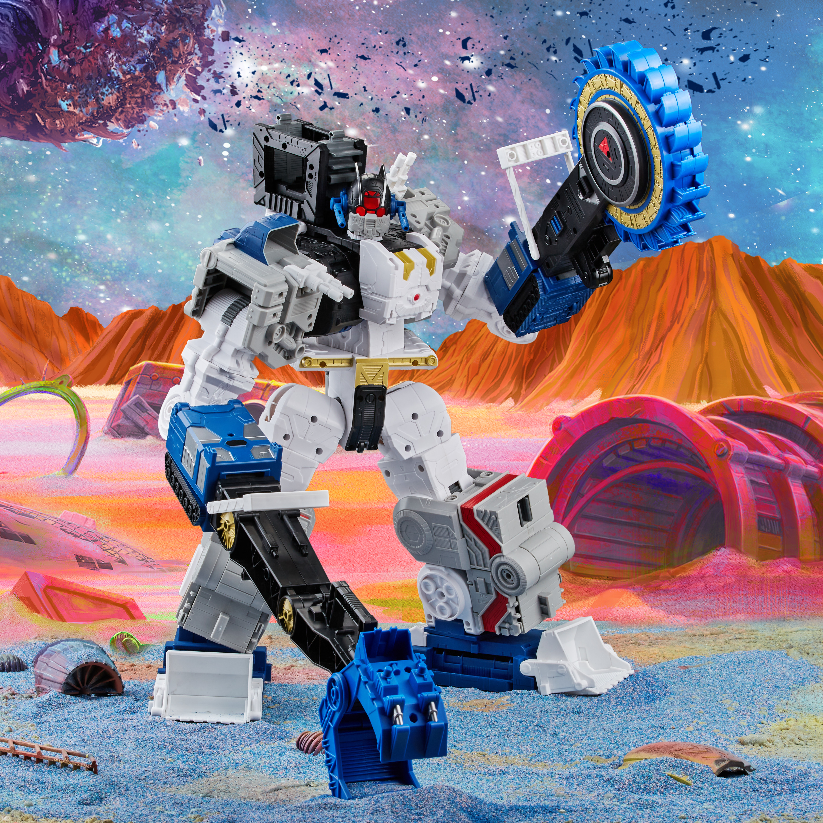 Un giocattolo robot bianco e blu è su una superficie sabbiosa blu. Lo sfondo raffigura un paesaggio alieno colorato.