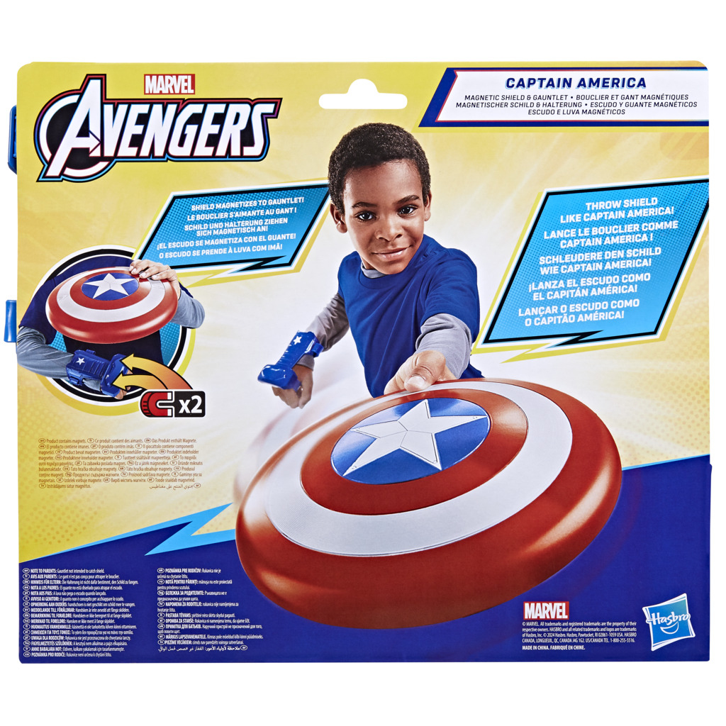 Un ragazzo tiene in mano uno scudo e un guanto di Captain America, con la confezione del prodotto sullo sfondo.