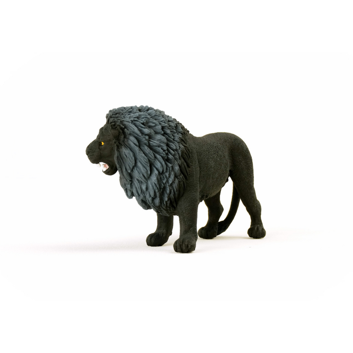Un giocattolo di leone nero con criniera grigia è su una superficie bianca, con la bocca aperta. Il leone guarda a sinistra.