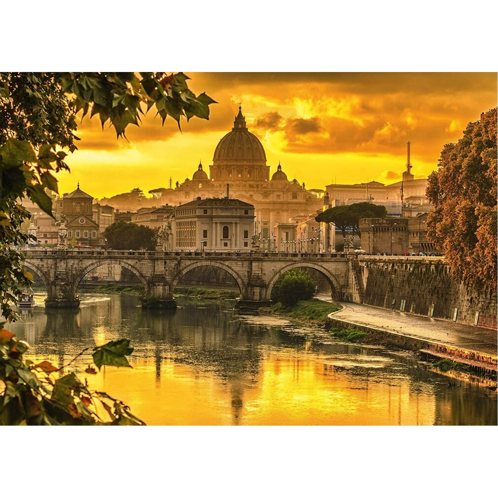 Rom bei Sonnenuntergang. Eine Brücke überspannt den Fluss, im Hintergrund der Petersdom unter goldenem Himmel. Bäume rahmen die Aufnahme ein.