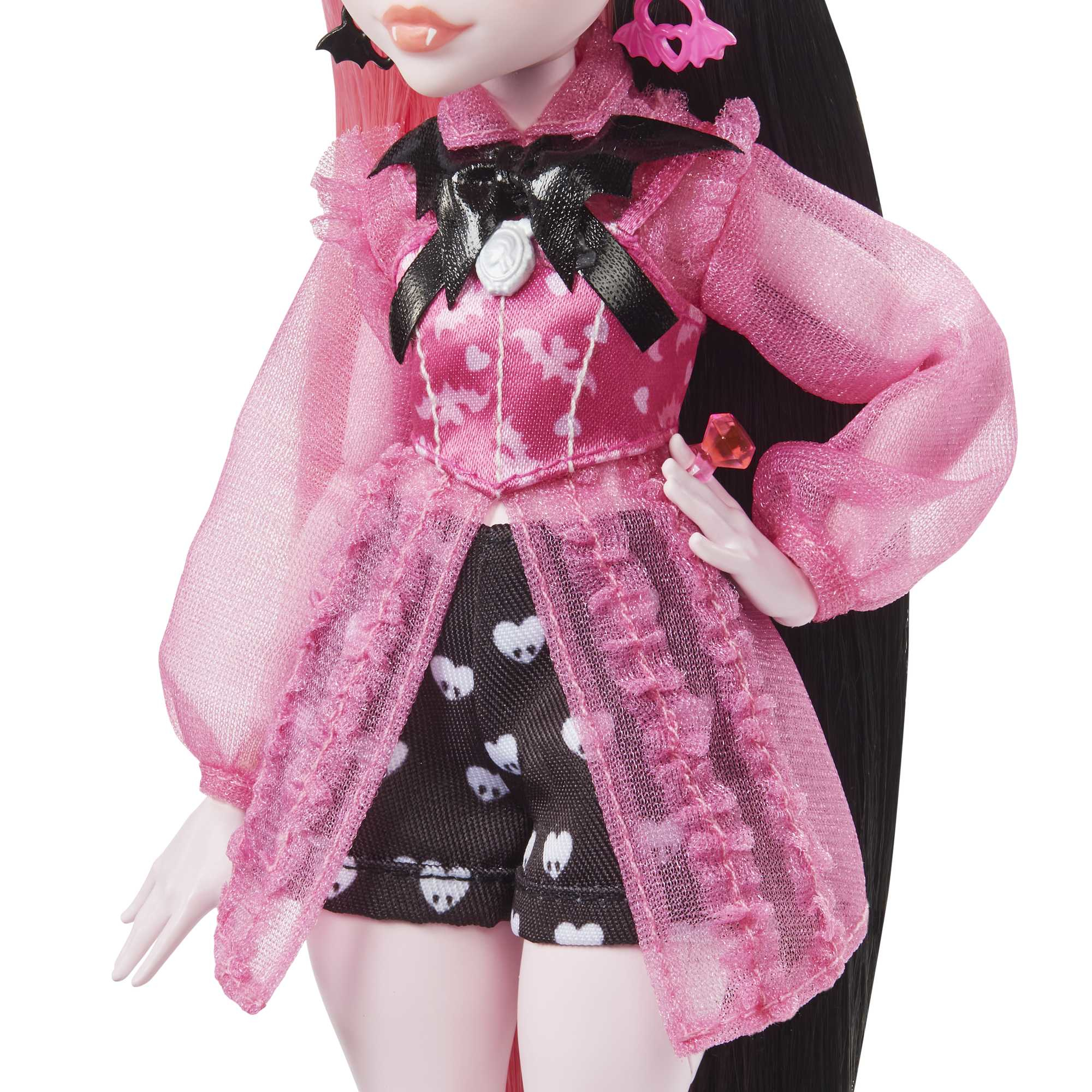 Puppe mit rosa Kleid und schwarzen Shorts mit weißen Herzen. Hat schwarzes Haar mit rosa Strähnen und Fledermauszubehör.