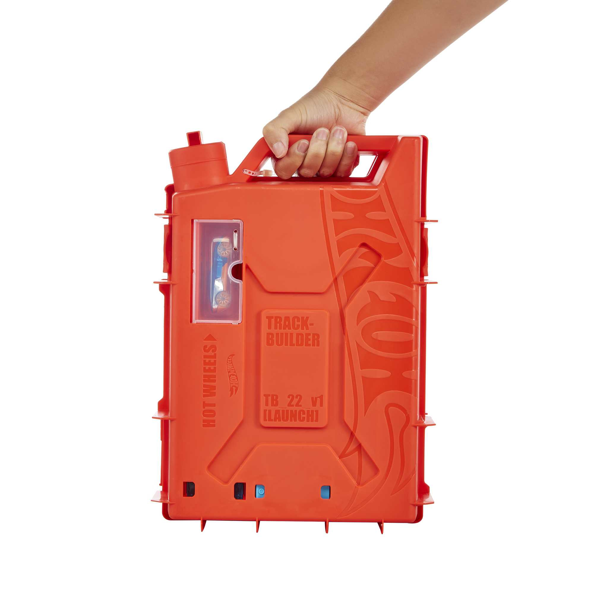 Ręka trzyma pomarańczową walizkę Hot Wheels Track Builder. W środku jest samochód. Tło jest białe.