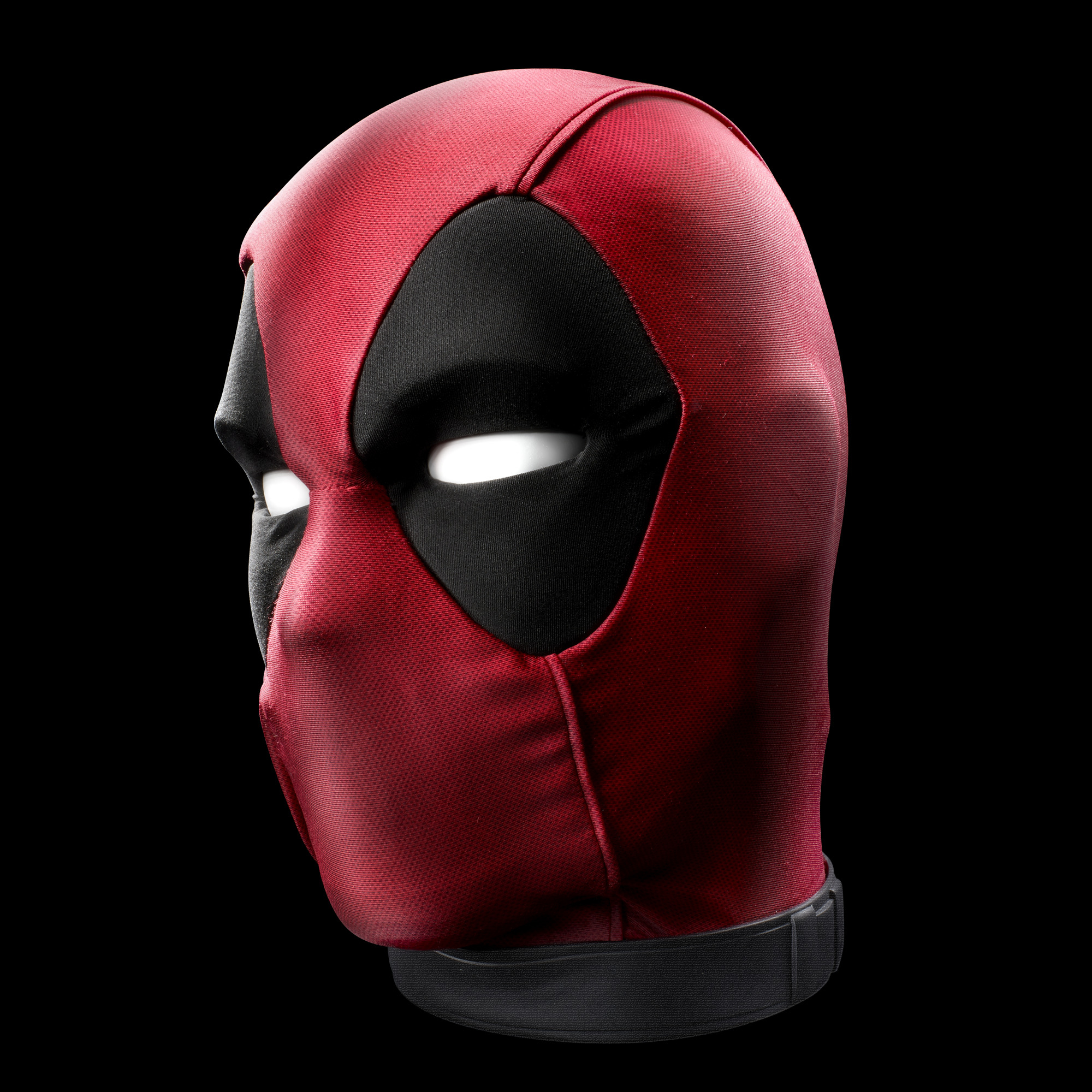 Máscara de Deadpool. Tela roja con aberturas negras para ojos y boca. Fondo negro.