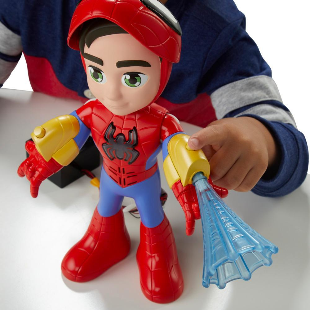 Un niño sostiene un juguete de Spider-Man. El juguete es rojo, azul y amarillo con un accesorio azul en forma de telaraña.