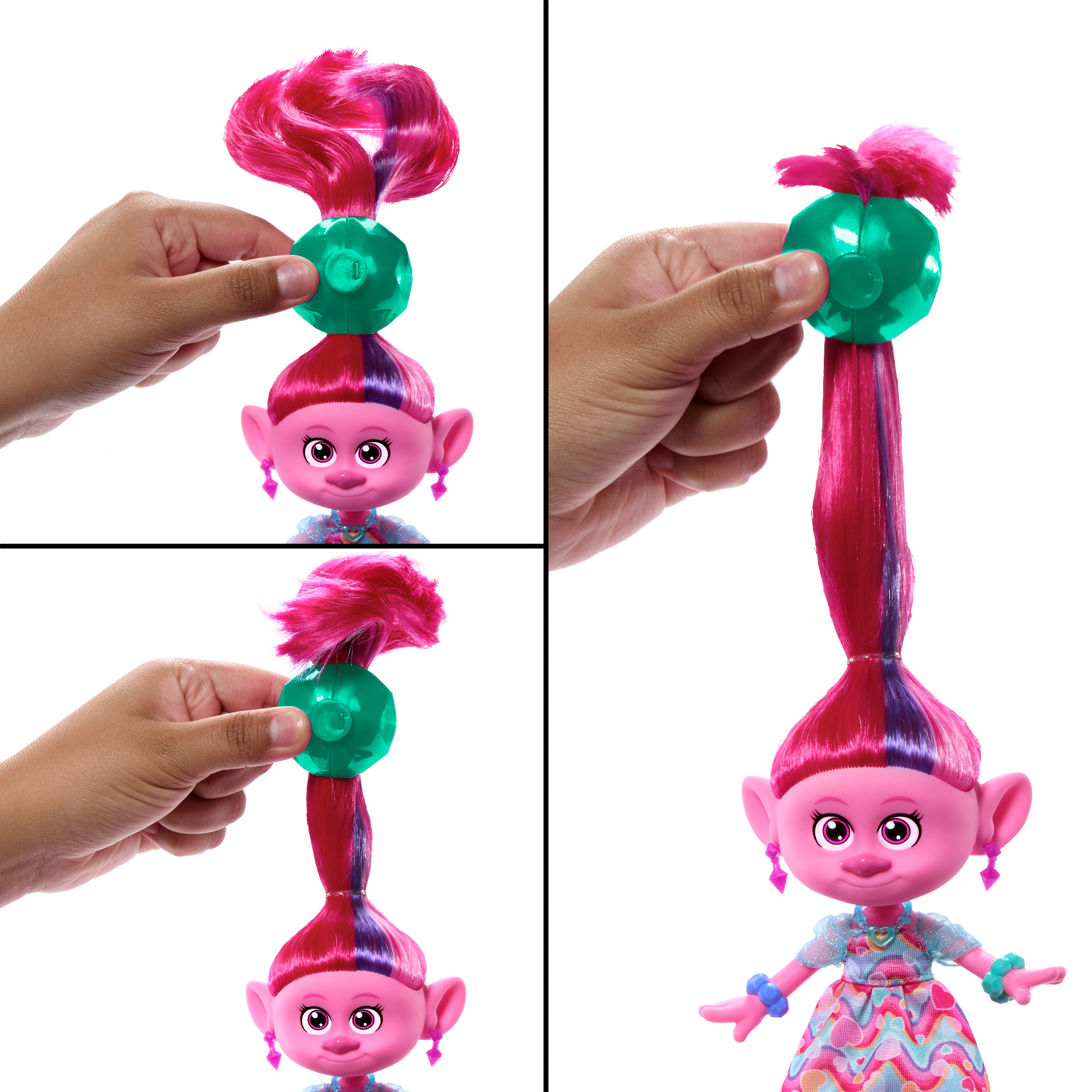 Eine Puppe mit rosa Haaren wird bespielt. Eine Hand hält ein grünes Edelstein-Stück an die Haare.