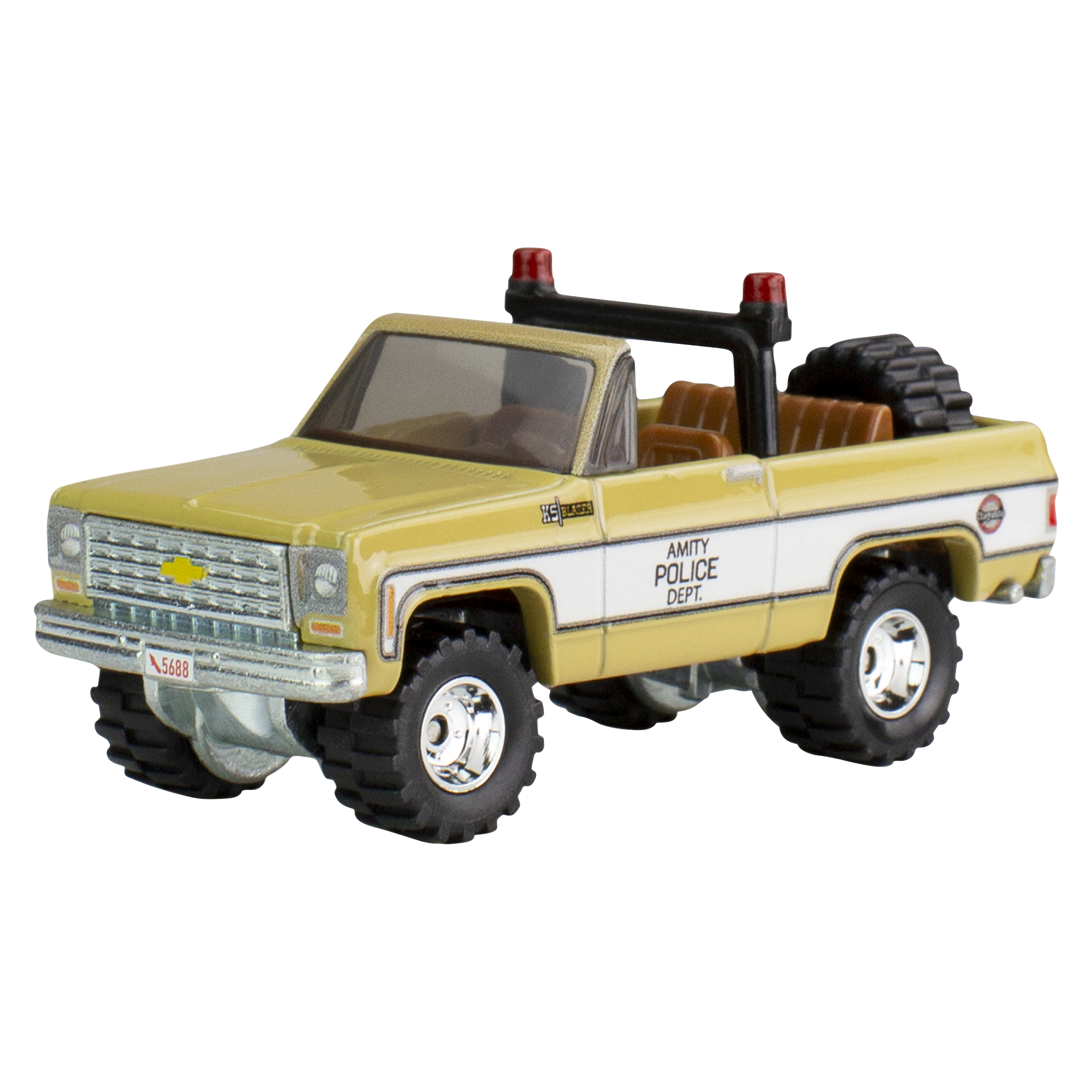 Żółta ciężarówka zabawka z napisem 'Amity Police Dept.' z boku. Ma czarne opony i czerwone światła.