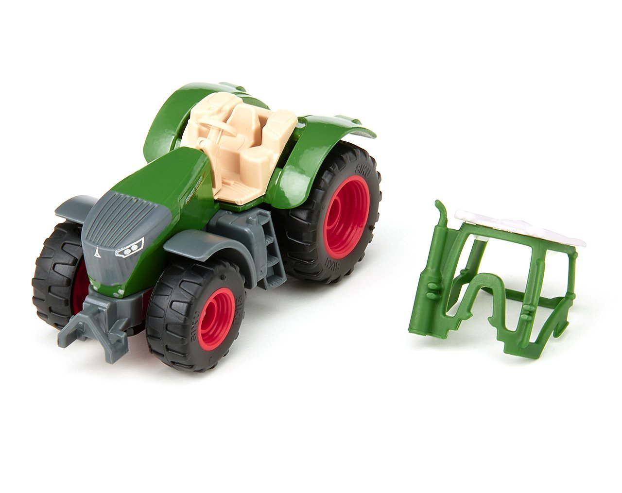 Zielony traktor zabawka z czerwonymi kołami i oddzielną zieloną ramą leży na białej powierzchni.