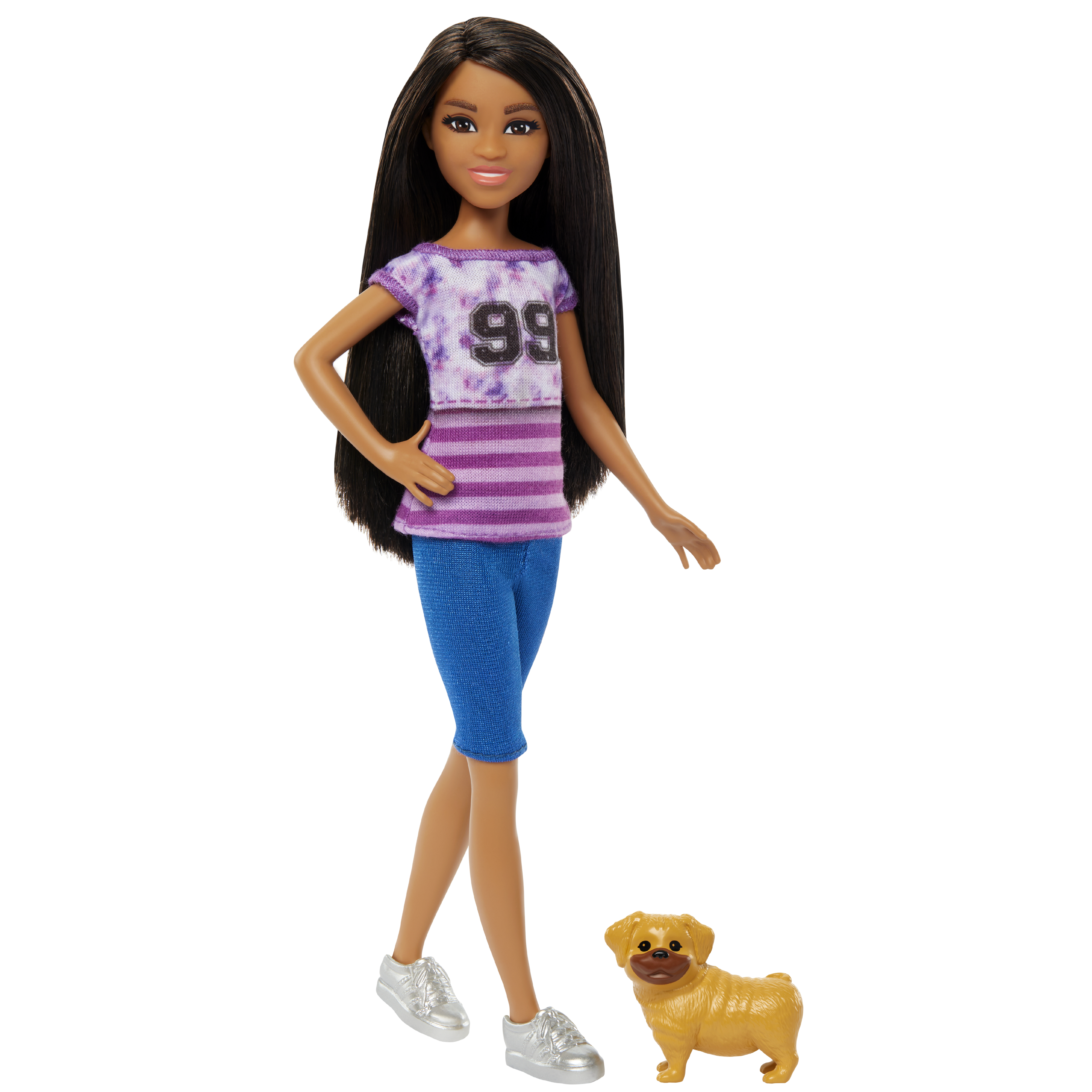 Eine Puppe mit dunklem Haar, lila Oberteil, blauen Shorts und silbernen Schuhen. Ein kleiner Hund liegt zu Füßen der Puppe.