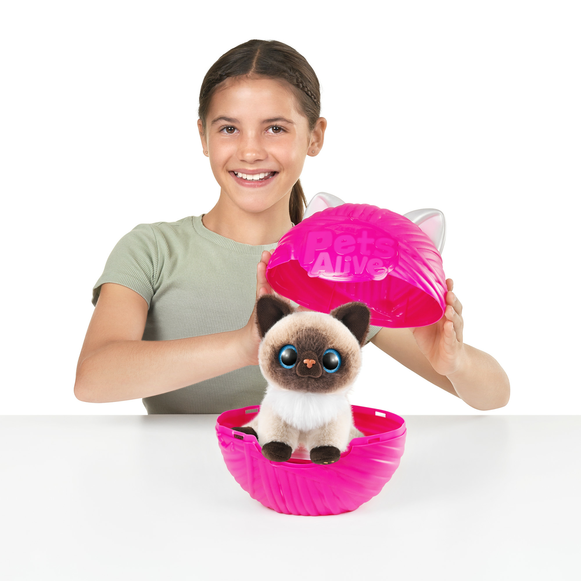 Una ragazza tiene in mano un contenitore giocattolo rosa con un gattino giocattolo all'interno. Il contenitore ha un coperchio con orecchie di gatto.