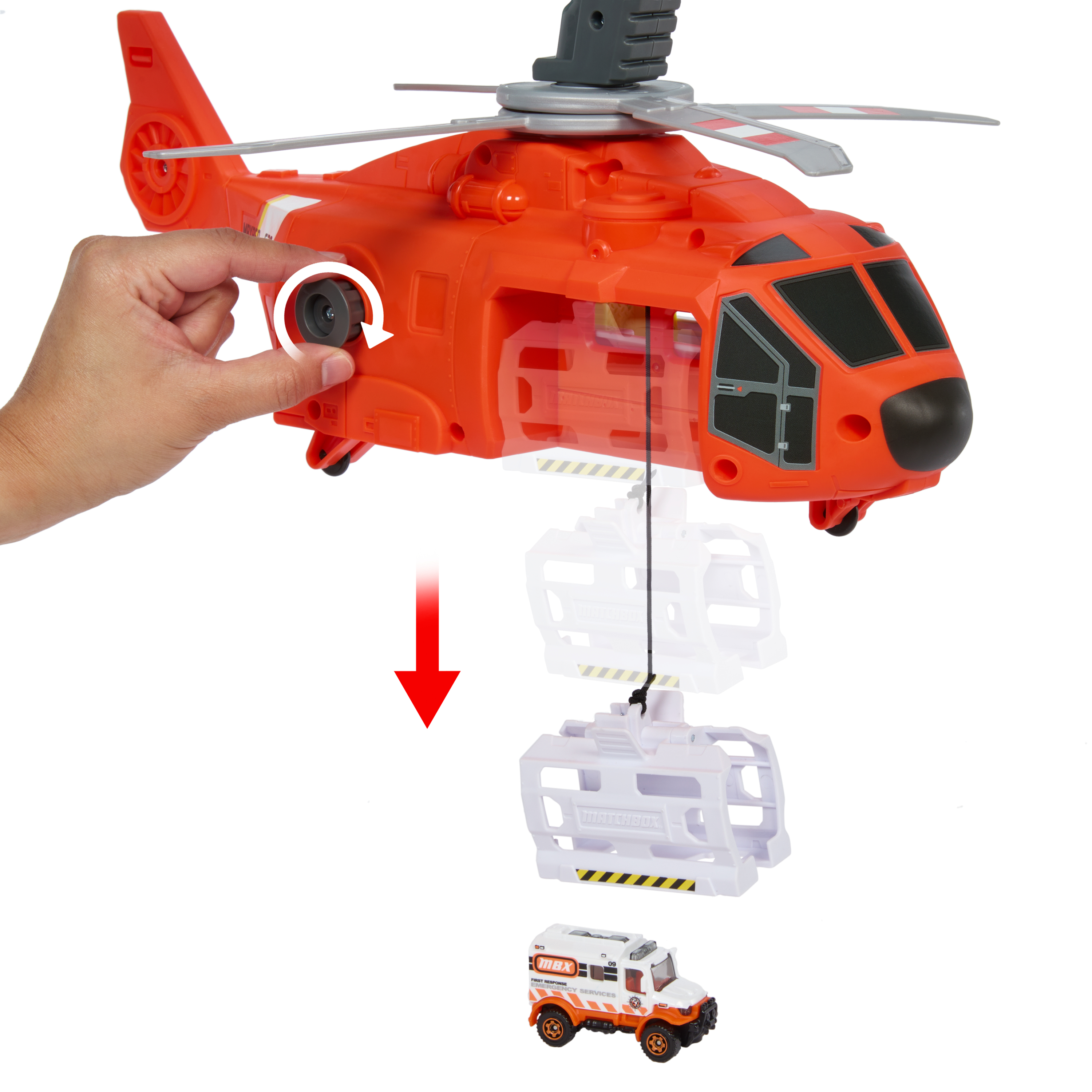 Zabawkowy helikopter z kontenerem i karetką. Ręka obraca koło w helikopterze.