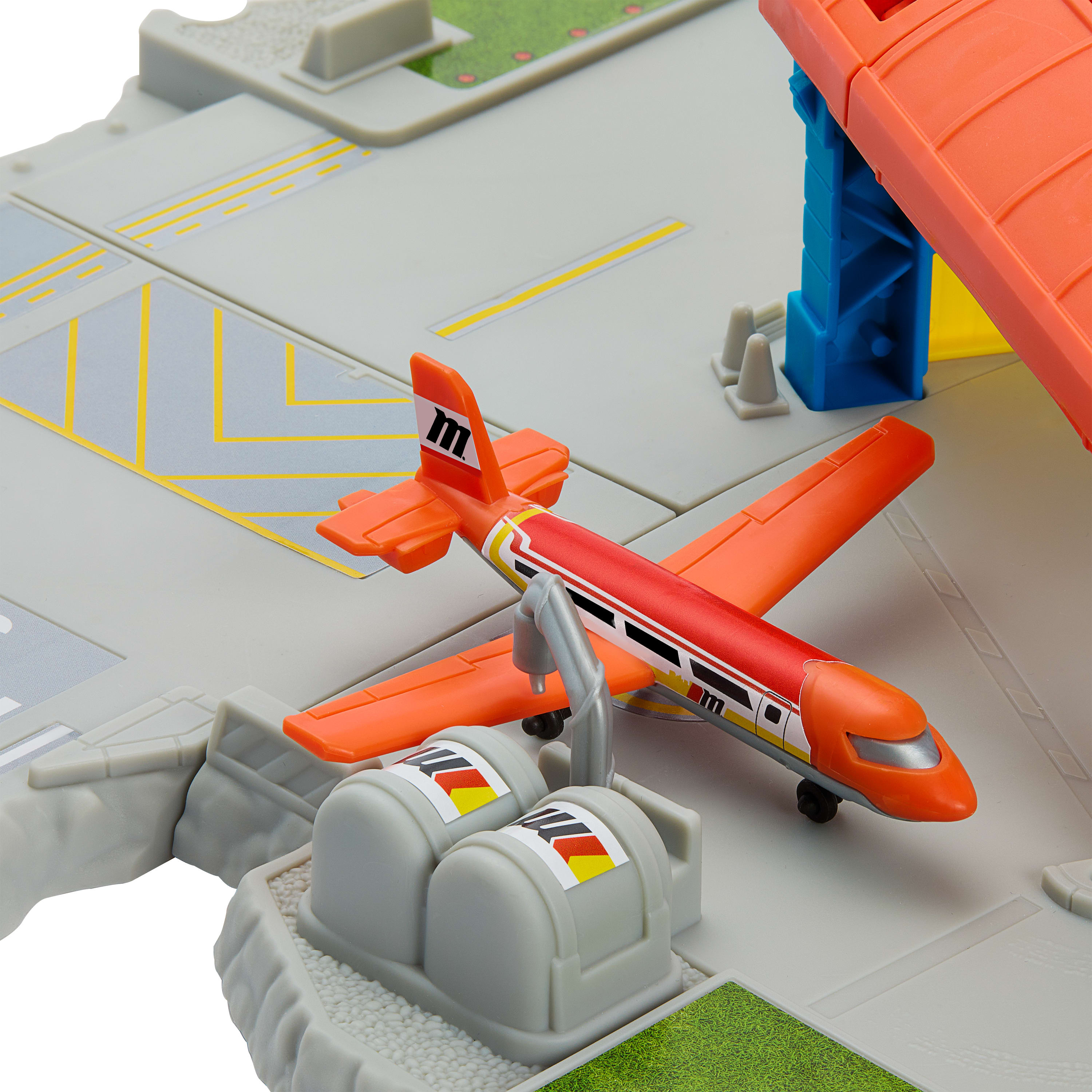 Spielzeug-Flughafenszene mit orangefarbenem Flugzeug, Treibstofftanks und orangefarbenen und blauen Strukturen.