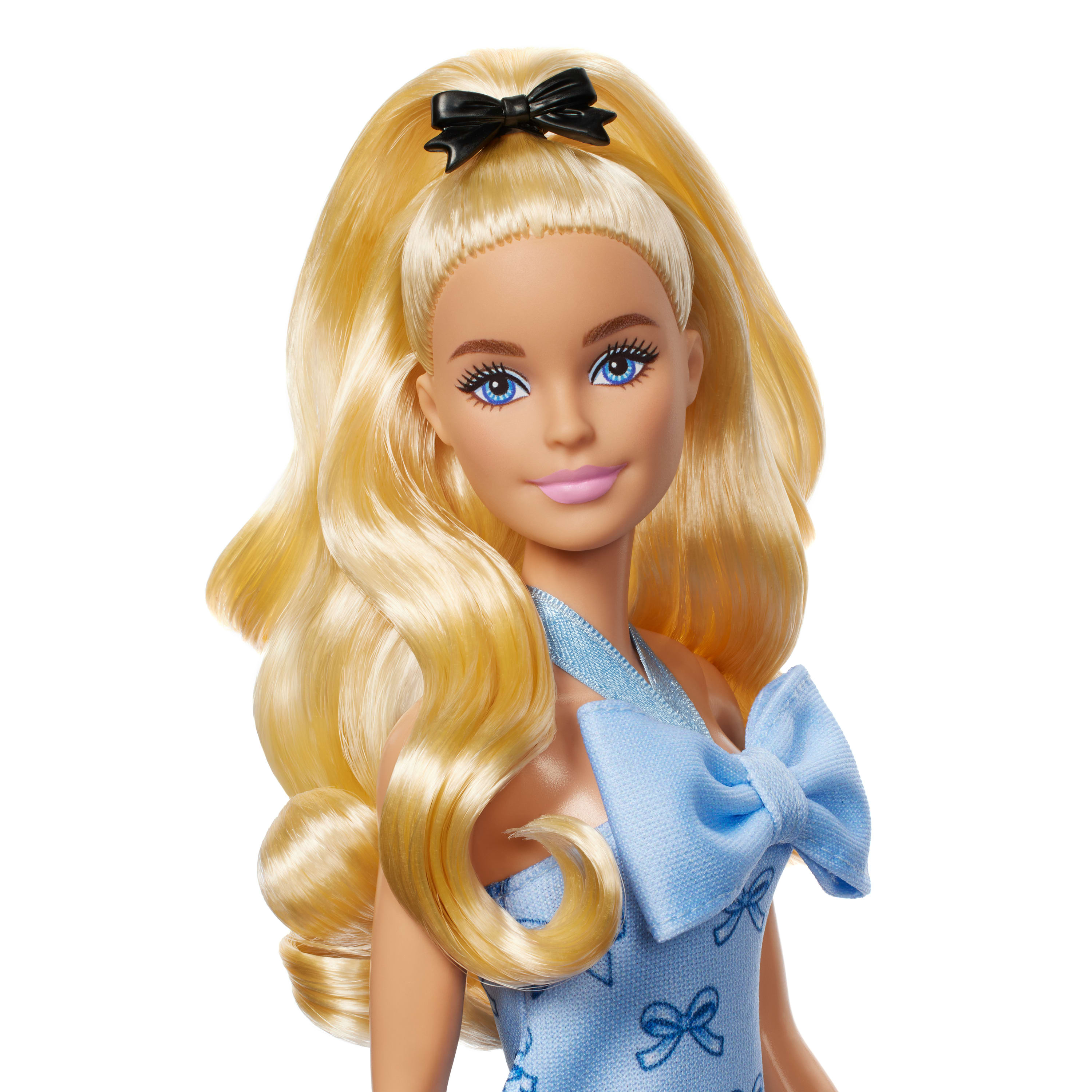 Blonde Barbie-Puppe mit blauen Augen, trägt ein hellblaues Kleid mit Schleifen. Ihre Haare sind mit einer schwarzen Schleife hochgesteckt.