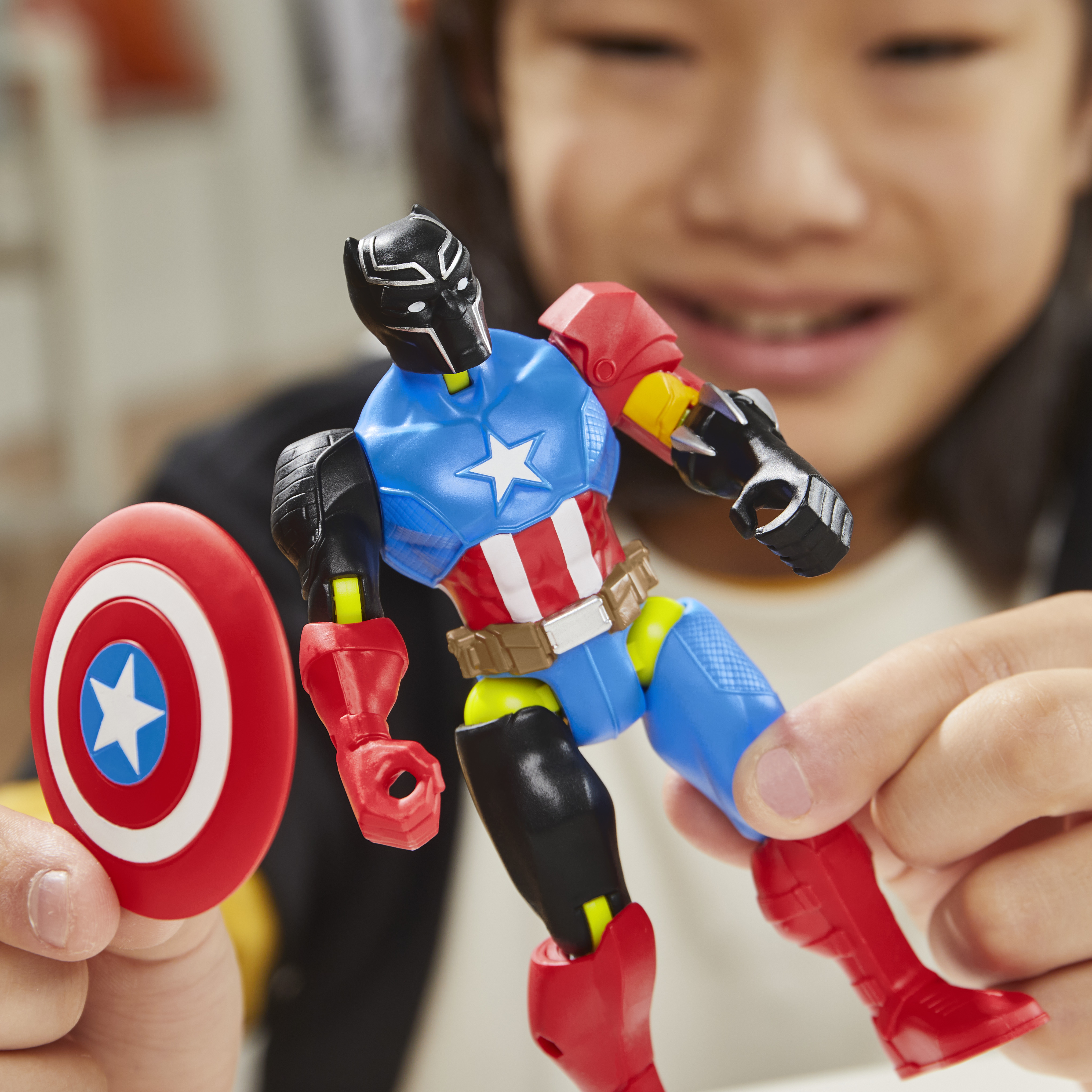 Un niño sostiene una figura de juguete, un híbrido de Capitán América y Pantera Negra, con escudo. La figura tiene colores mixtos.