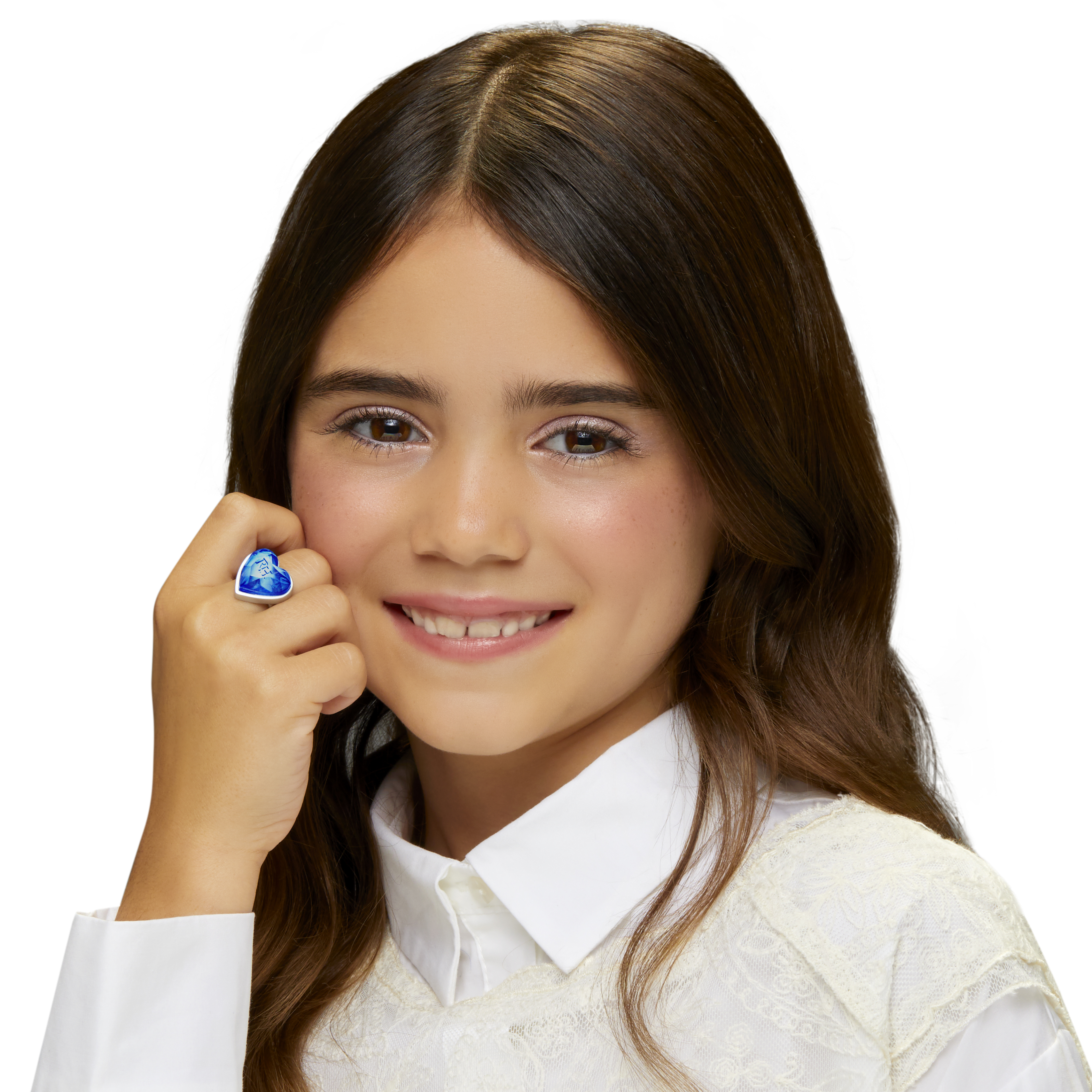 Dziewczyna uśmiecha się, ubrana w białą koszulę i niebieski pierścionek w kształcie serca. Długie brązowe włosy i białe tło.