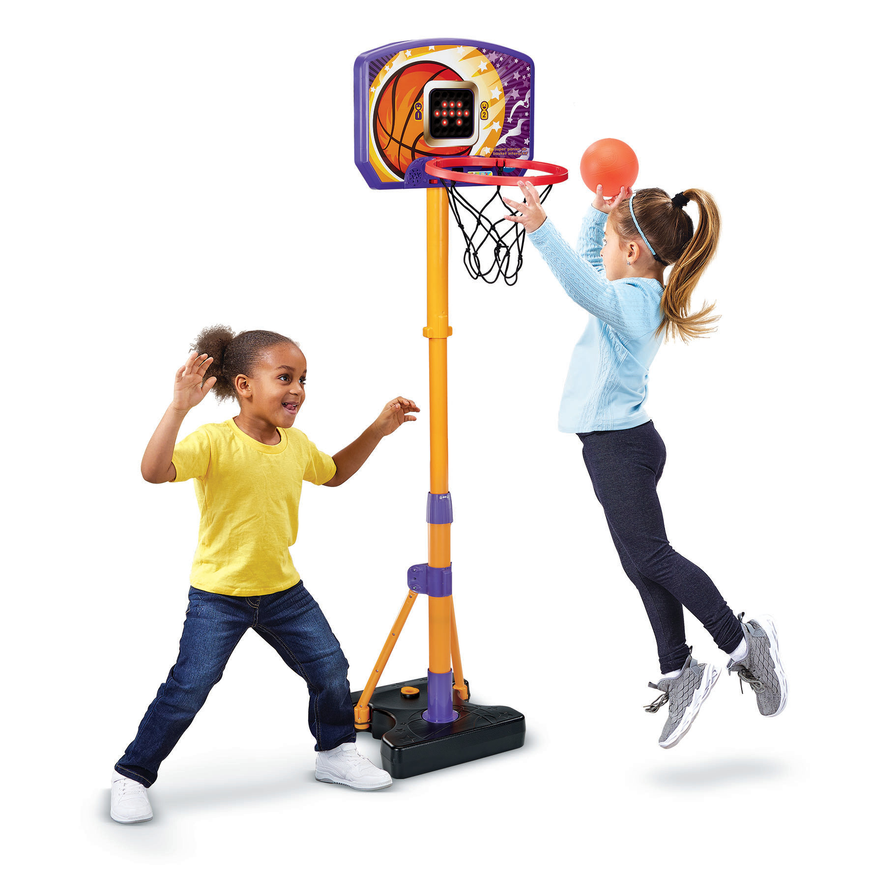 Due ragazze giocano a basket. Una salta per tirare, l'altra sorride. Canestro sullo sfondo.