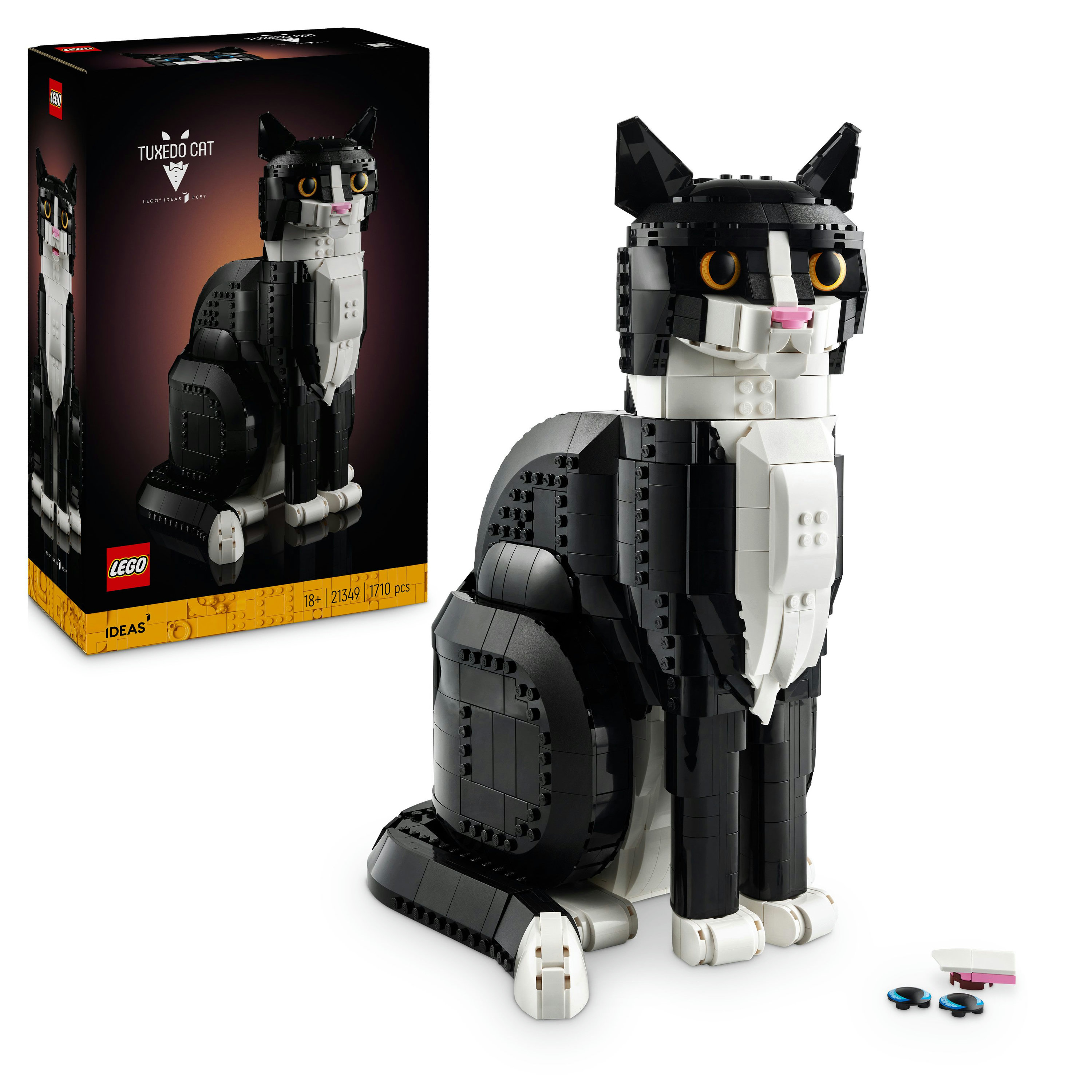 Model kota LEGO w kolorze czarno-białym, siedzący. Pudełko jest po lewej stronie. Małe części z przodu.