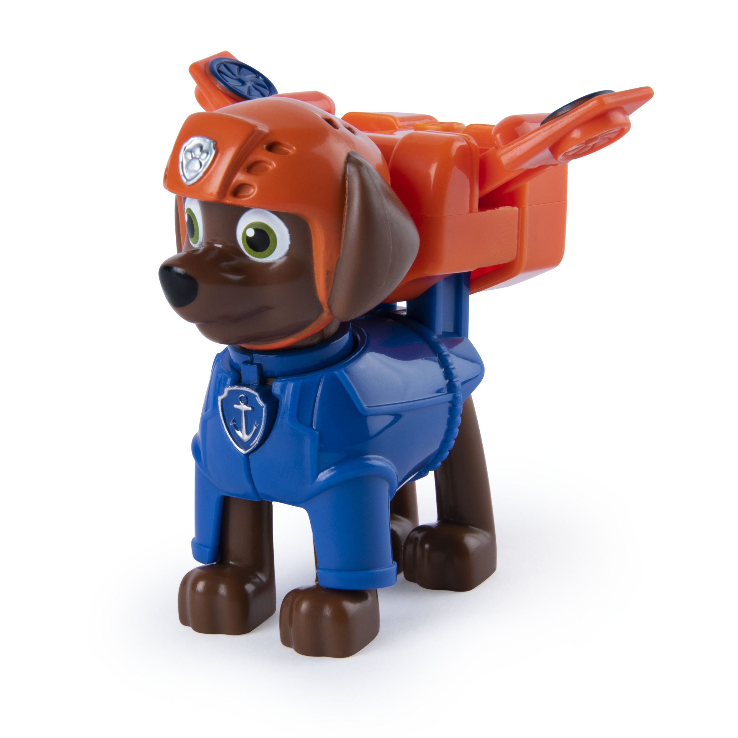 Un perro de juguete con uniforme azul y casco naranja. Tiene una mochila y está sobre una superficie blanca.