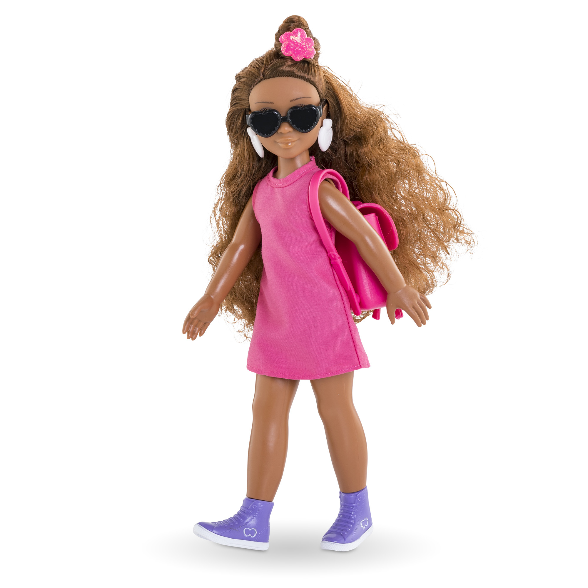Puppe mit Sonnenbrille, rosa Kleid, Rucksack und lila Schuhen. Braunes Haar mit Blume. Weißer Hintergrund.