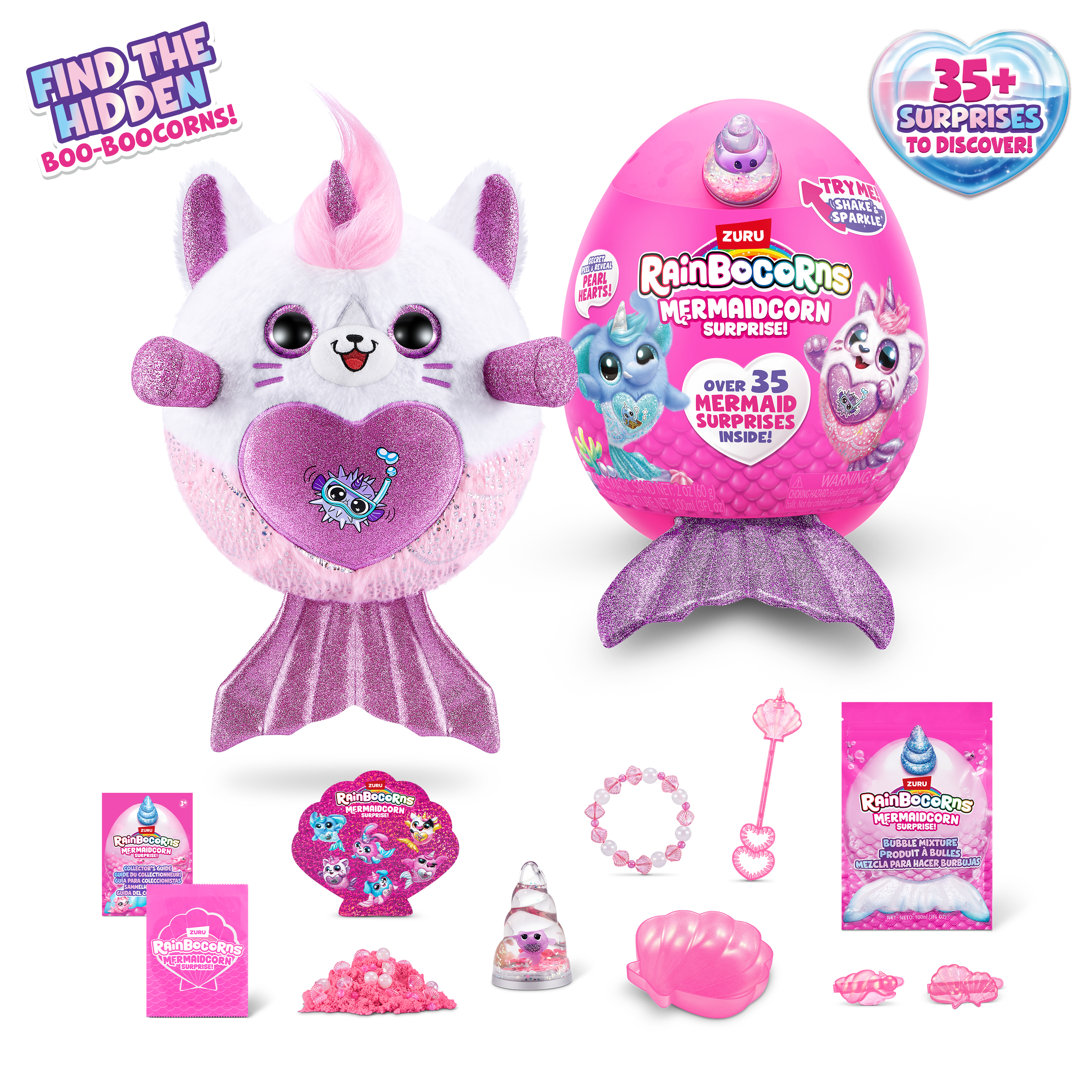 Obraz przedstawia zabawki i akcesoria Rainbocorns Mermaidcorn, w tym pluszaki, jajka i elementy niespodzianki, wszystko w jasnoróżowym kolorze.