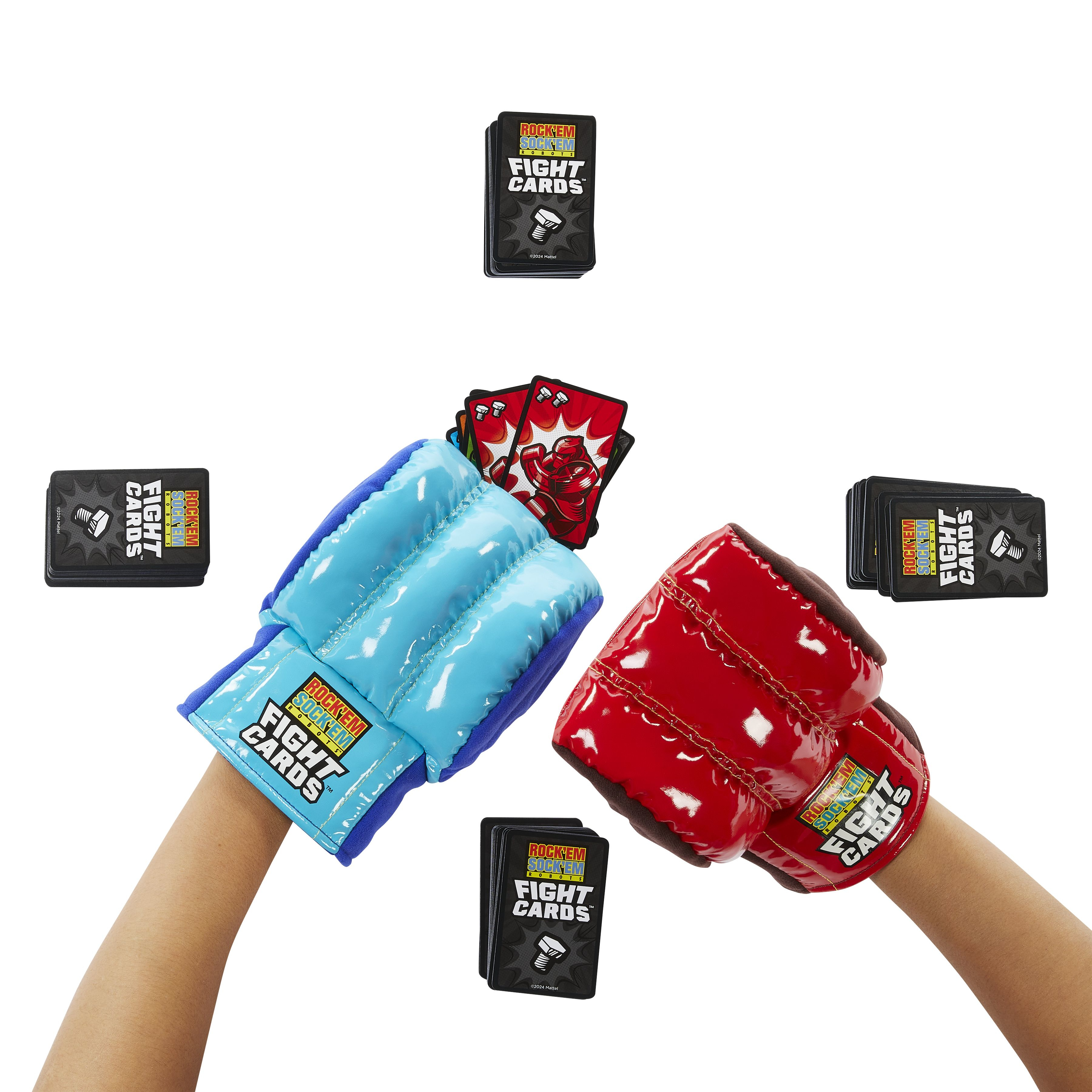 Manos con guantes de boxeo azules y rojos sosteniendo cartas con robots. También se ven varias pilas de cartas.