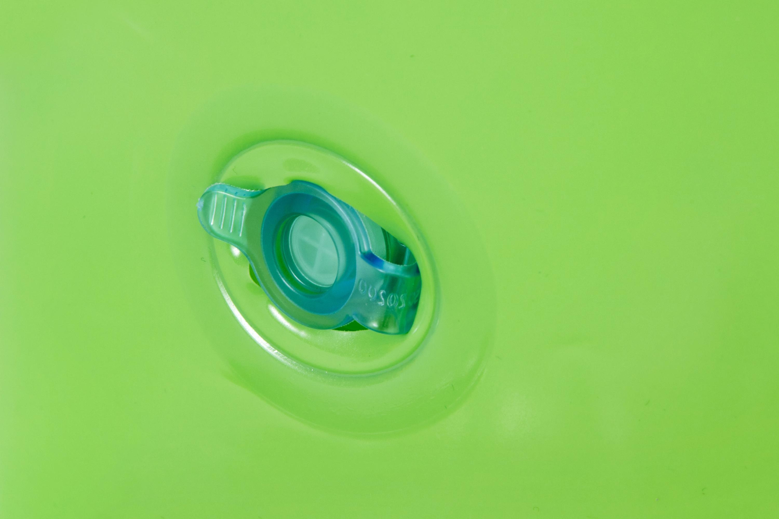 Primer plano de un inflable verde con una válvula azul. La válvula tiene texto blanco.