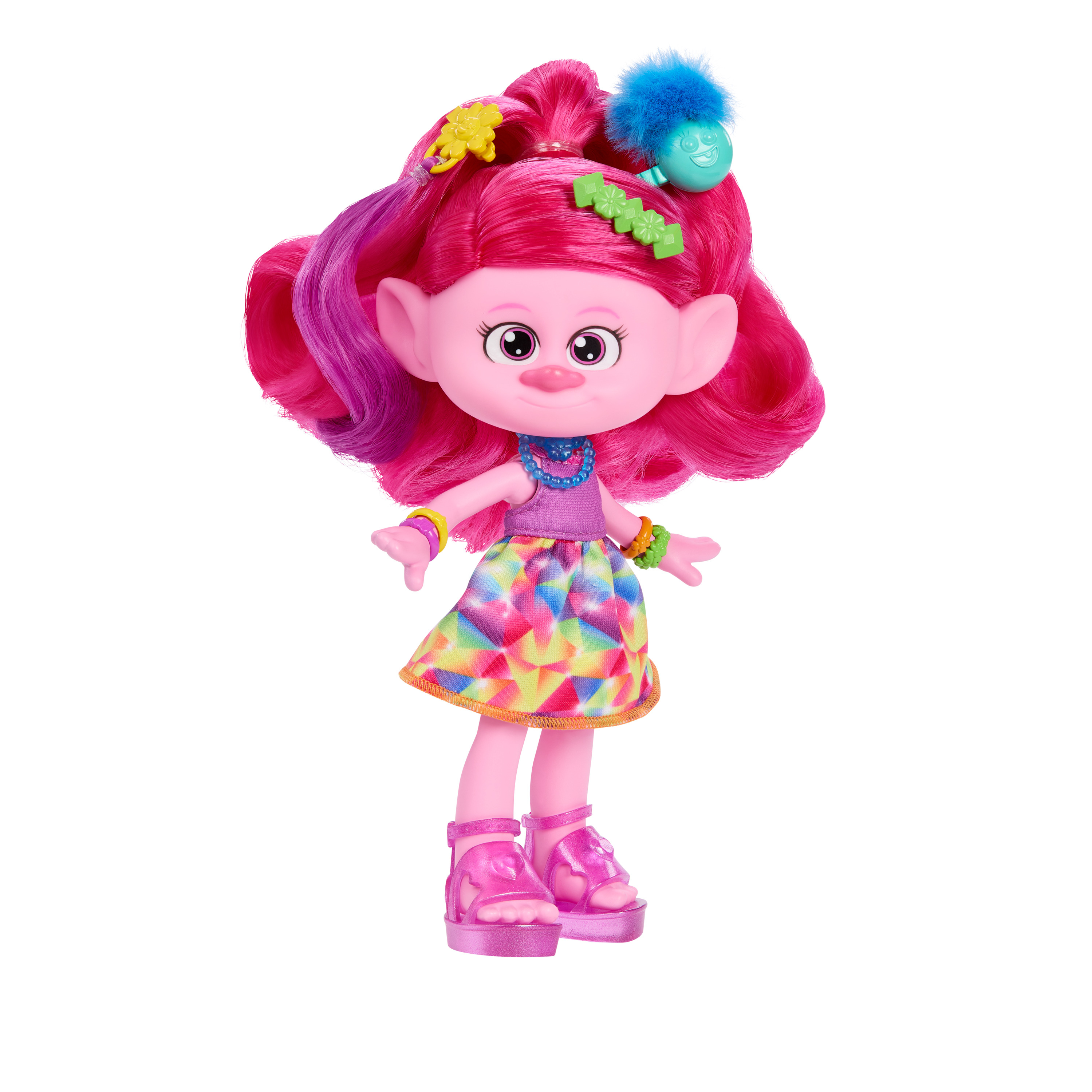 Eine rosa Troll-Puppe steht auf weißem Hintergrund. Sie hat rosa Haare und trägt ein buntes Kleid und rosa Schuhe.