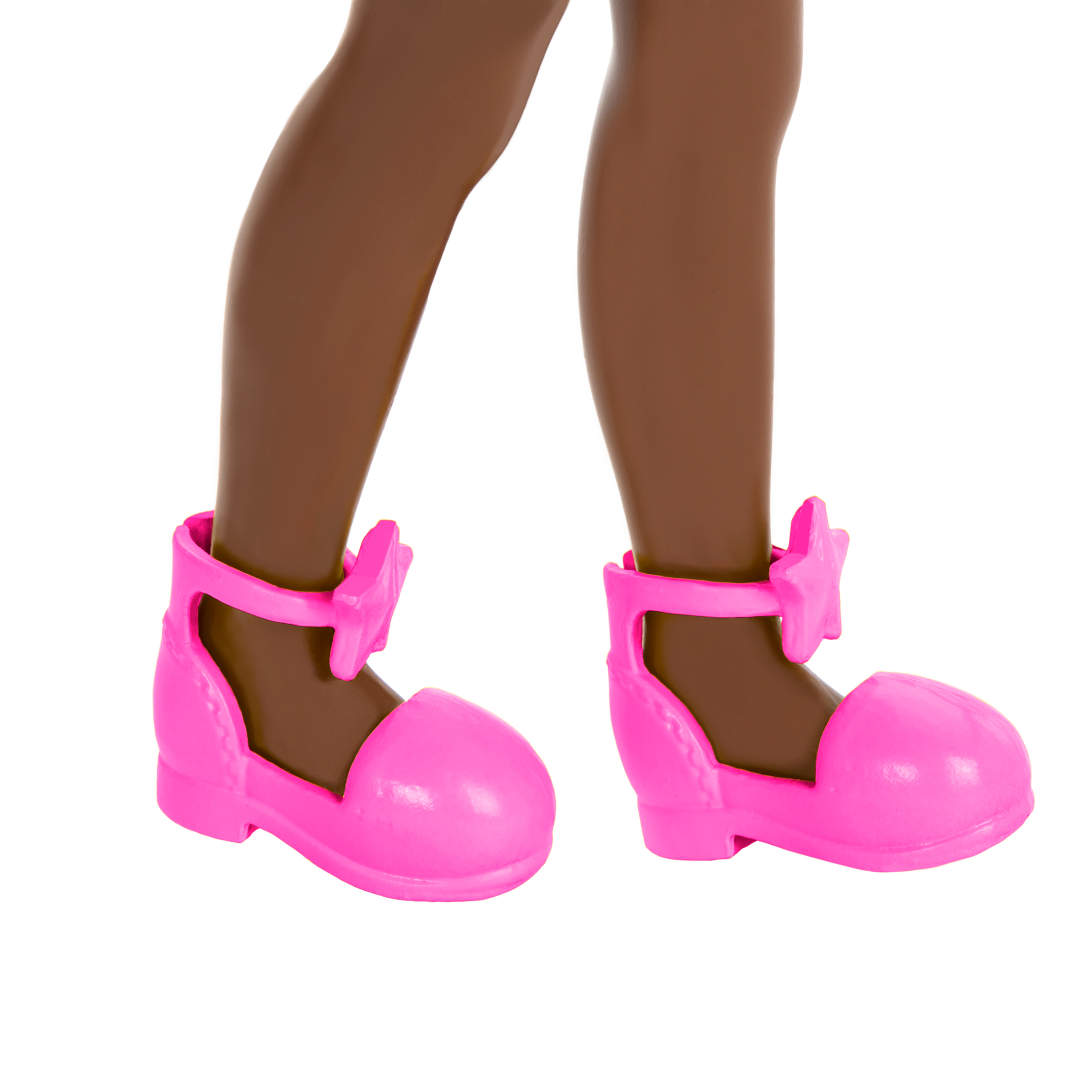 Nahaufnahme von Puppenbeinen und rosa Schuhen. Die Schuhe haben sternförmige Details an den Riemen.
