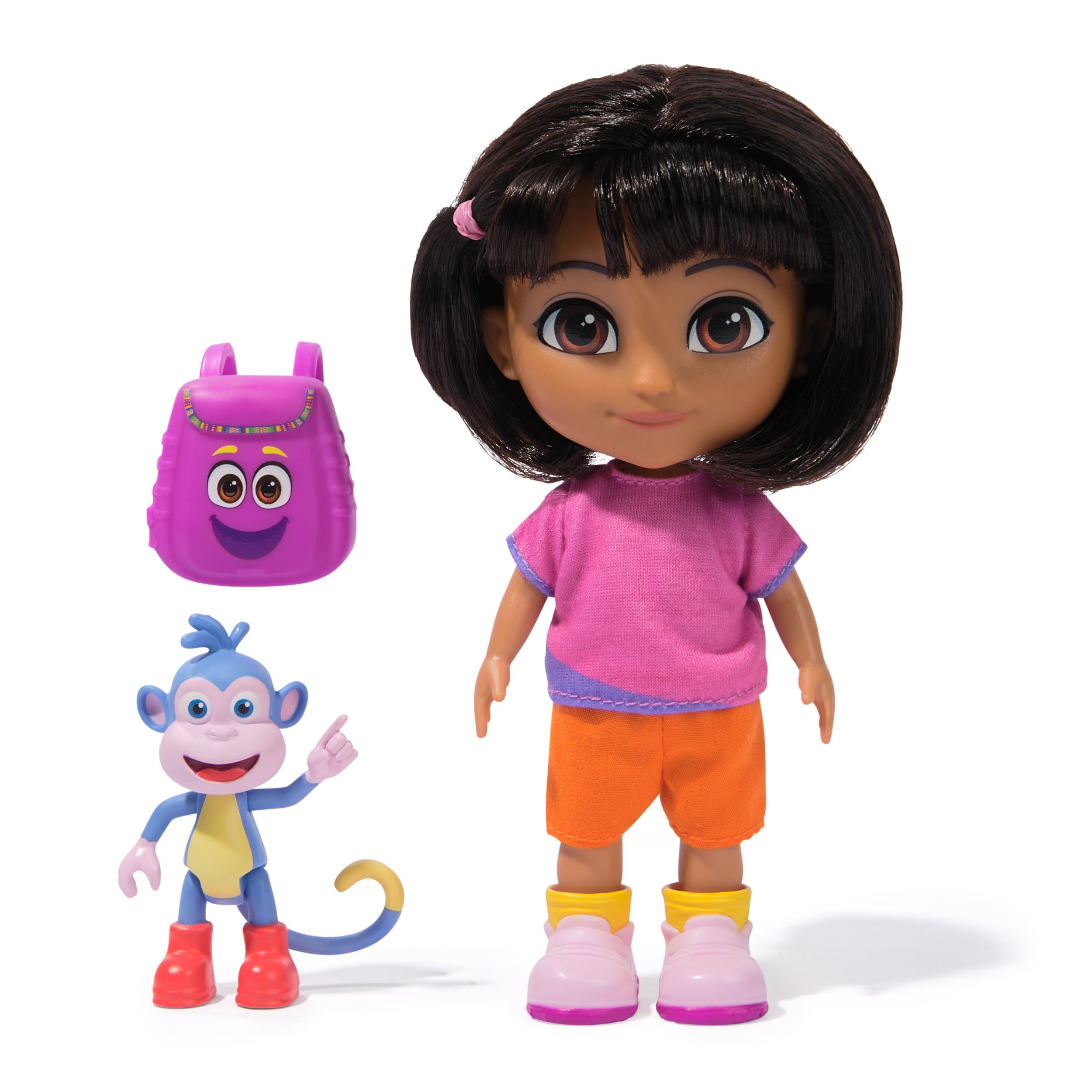 Muñeca Dora con mochila morada y figura de mono azul. Dora lleva camisa rosa, pantalones cortos naranjas y zapatos rosas.