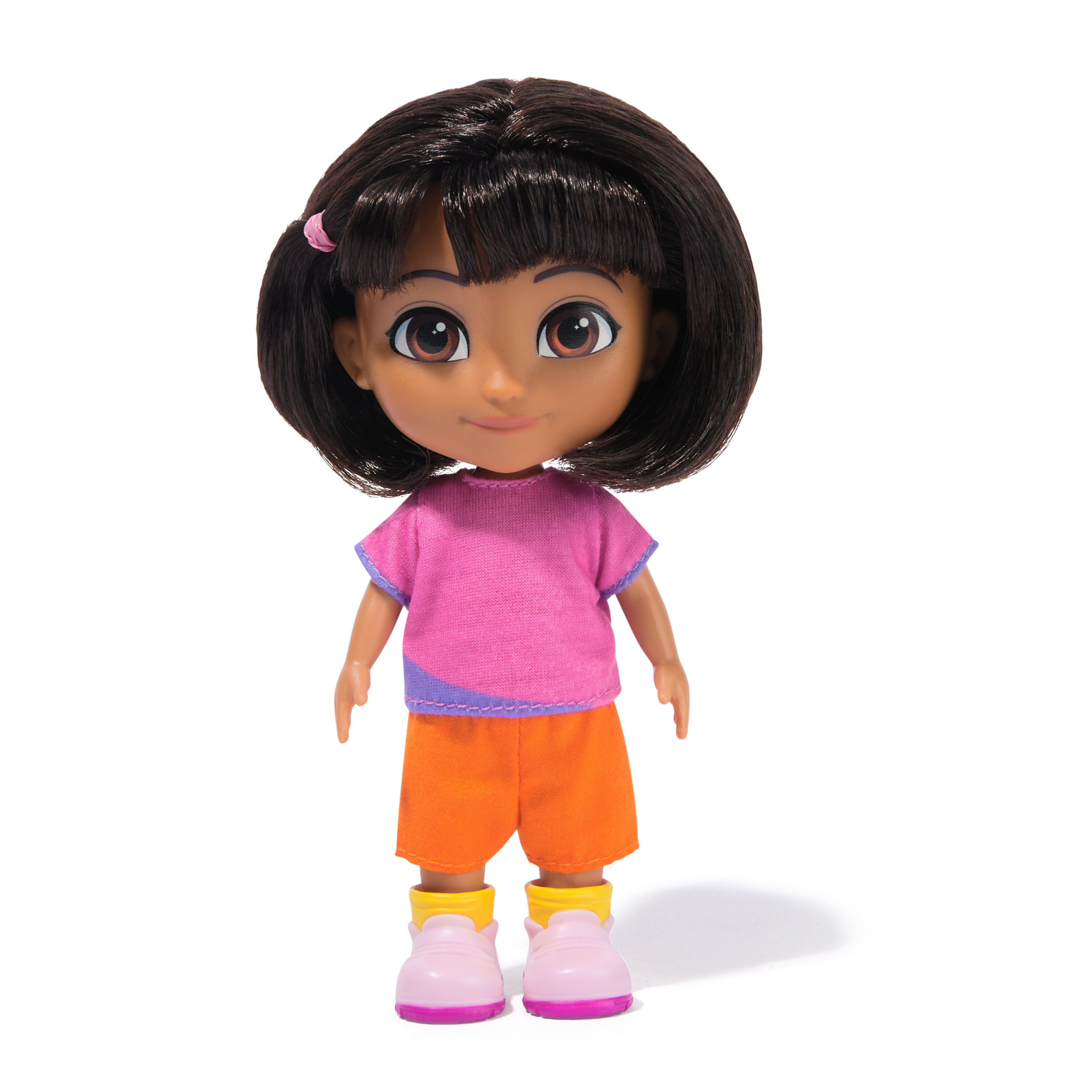 Muñeca de Dora la Exploradora con camisa rosa, pantalones cortos naranjas y zapatos rosas sobre fondo blanco.