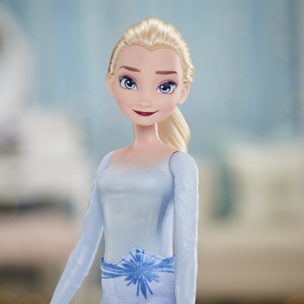 Eine Puppe von Elsa aus Frozen. Sie hat blondes Haar, blaue Augen und ein hellblaues Kleid mit einem Schneeflocken-Design auf der Taille.