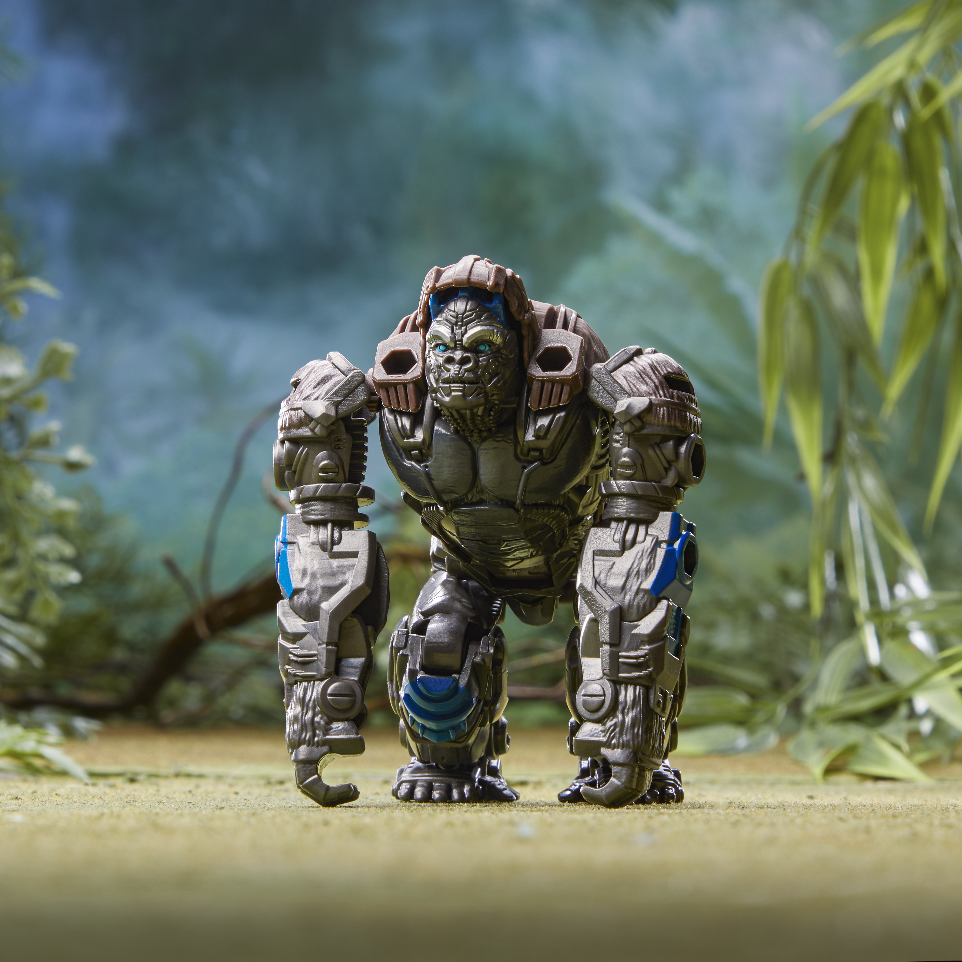 Un giocattolo robot gorilla metallico è in piedi su una superficie verde. Sfondo: scena di giungla sfocata.
