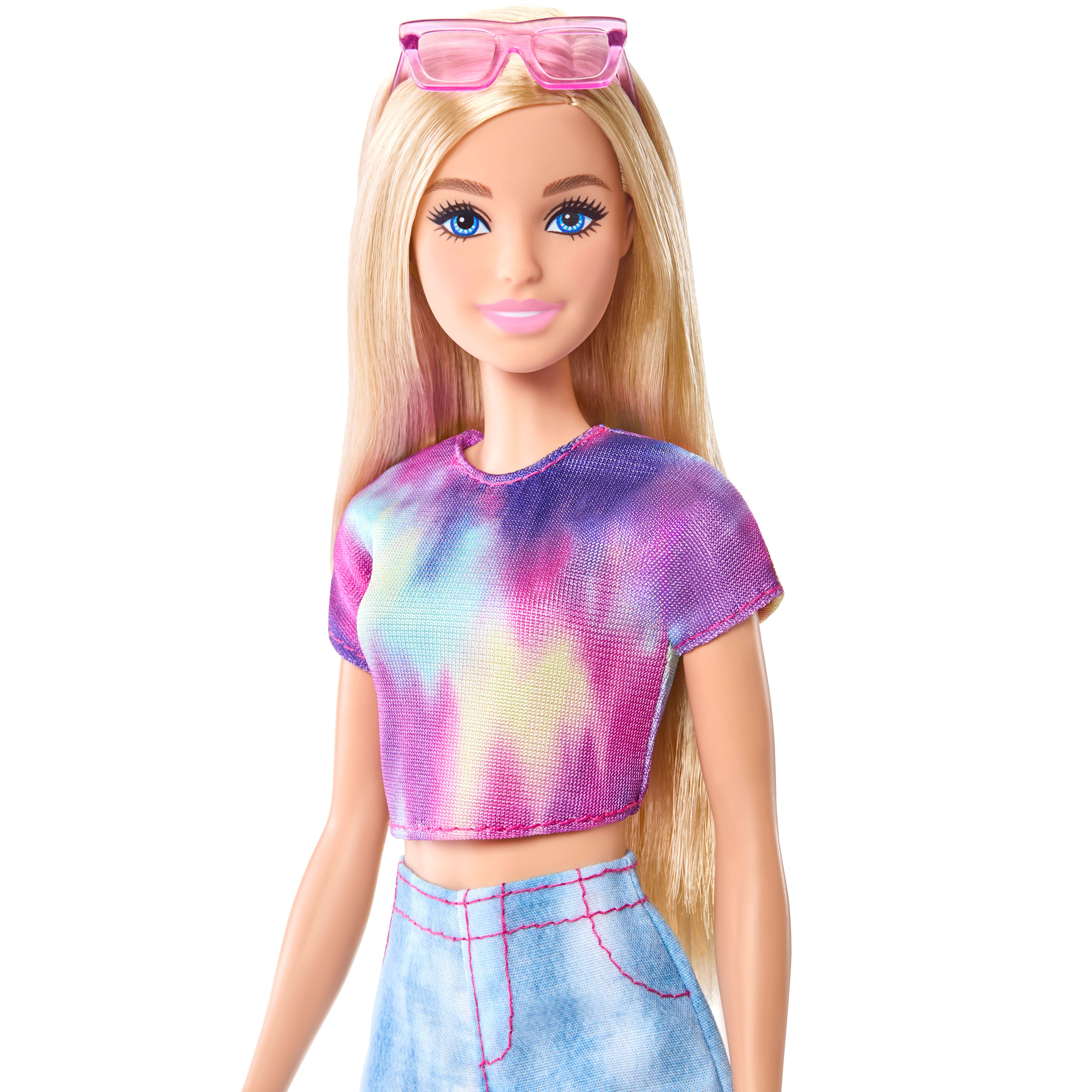 Barbie-Puppe mit blonden Haaren, rosa Sonnenbrille, Batik-Top und Jeansrock. Blaue Augen und rosa Lippen. Weißer Hintergrund.