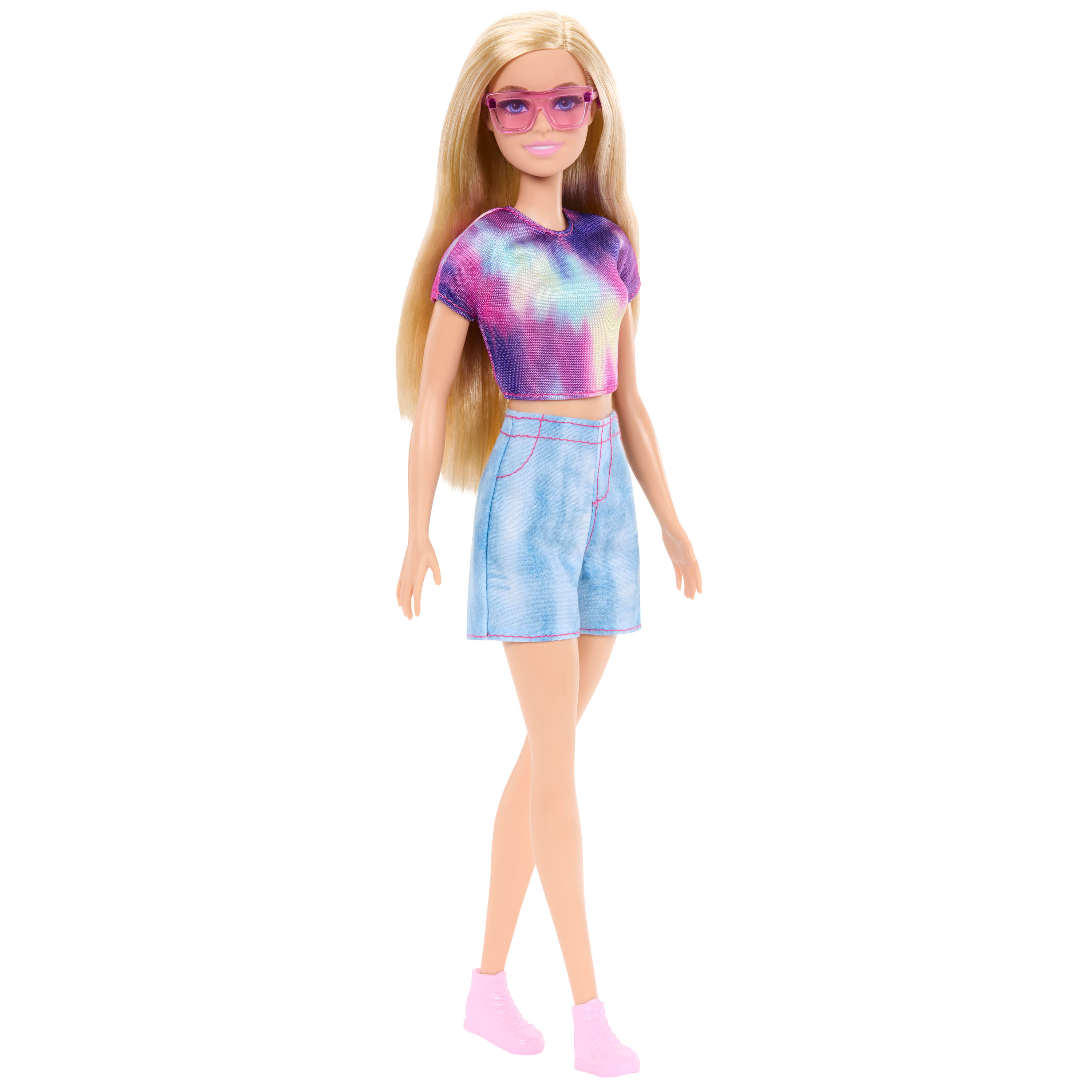 Eine Barbie-Puppe trägt ein Batik-T-Shirt, Jeansshorts, eine rosa Brille und Schuhe. Sie hat langes blondes Haar.