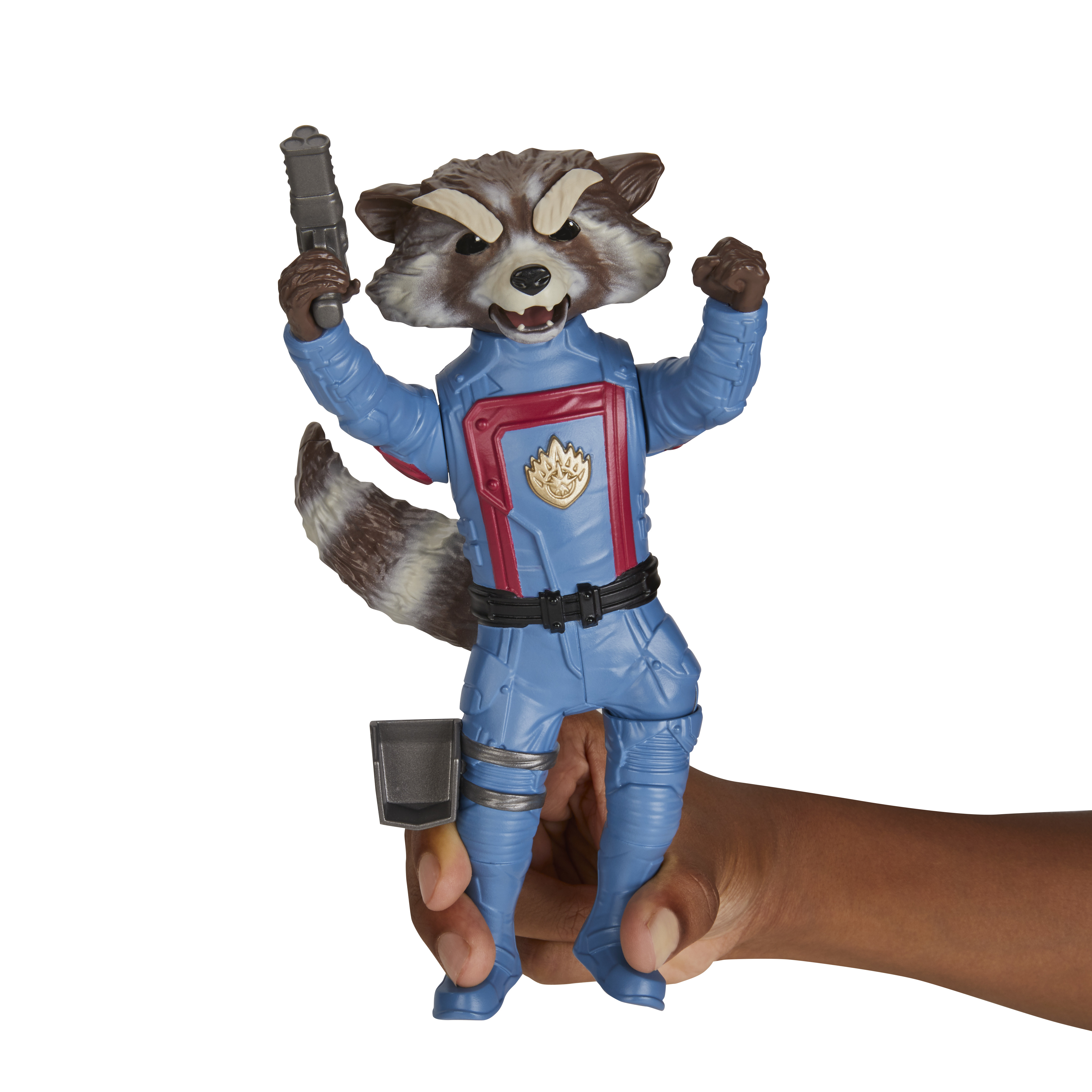 Figurka Rocket Raccoon w niebieskim garniturze, trzymająca broń, trzymana przez dłoń. Białe tło.