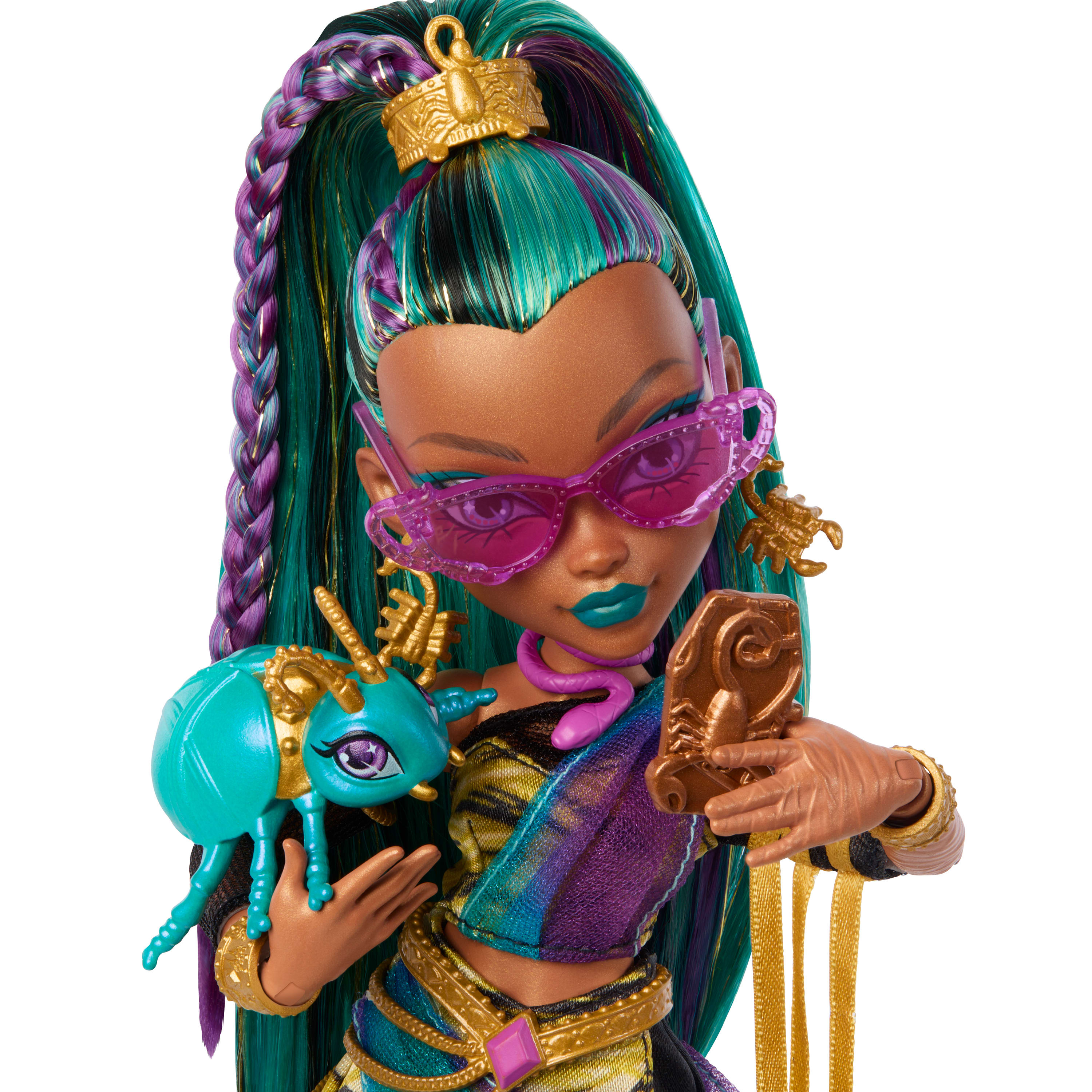 Muñeca con pelo verde azulado y morado, gafas moradas y un bicho verde azulado. Acentos dorados y collar de serpiente.
