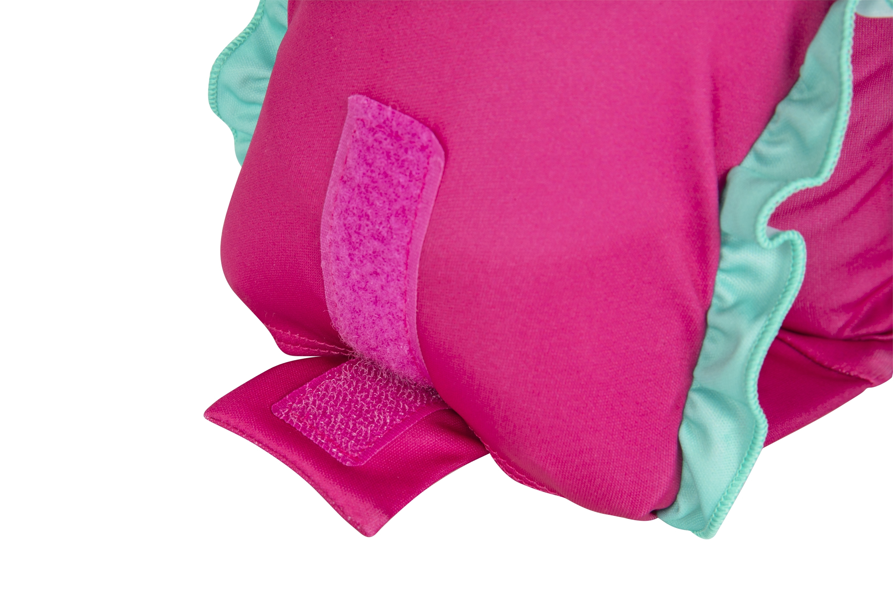 Nahaufnahme einer rosa Baby-Rettungsweste mit türkisfarbener Bordüre und Klettverschlüssen auf weißem Hintergrund.