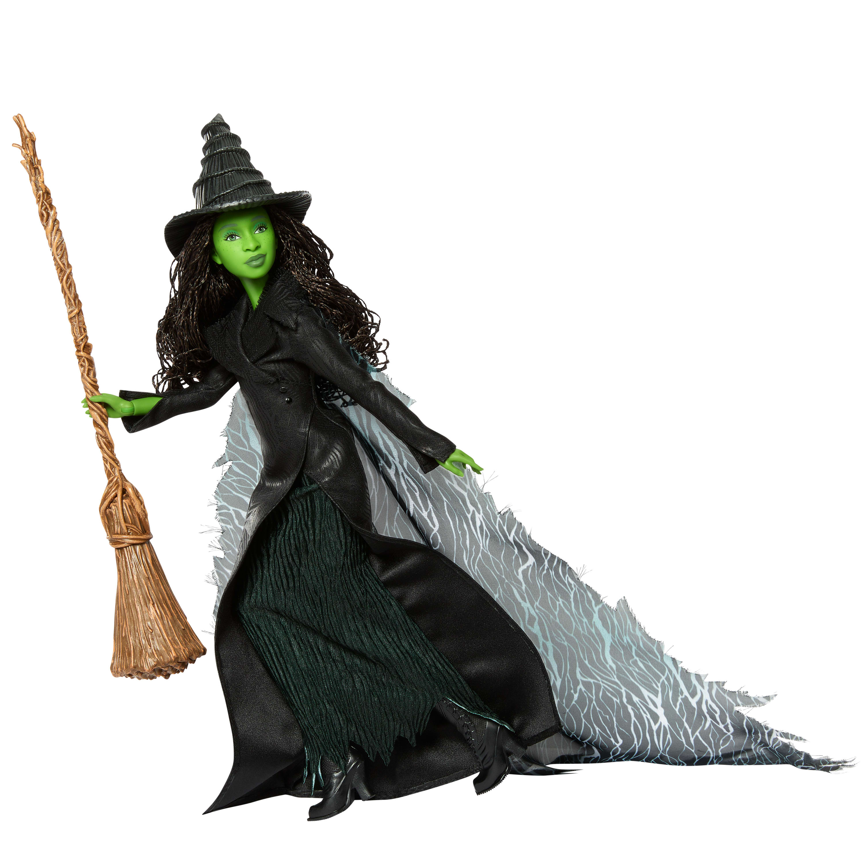 Eine grüne Hexenpuppe mit schwarzem Kleid und Hut, die einen Besen und einen grauen Umhang mit weißen Mustern hält.