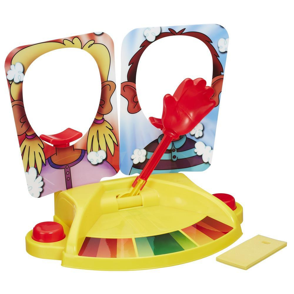 Żółta gra z dwoma wycięciami na twarz. Czerwona dłoń na patyku jest pośrodku. Podstawa ma kolory i żółtą gąbkę.