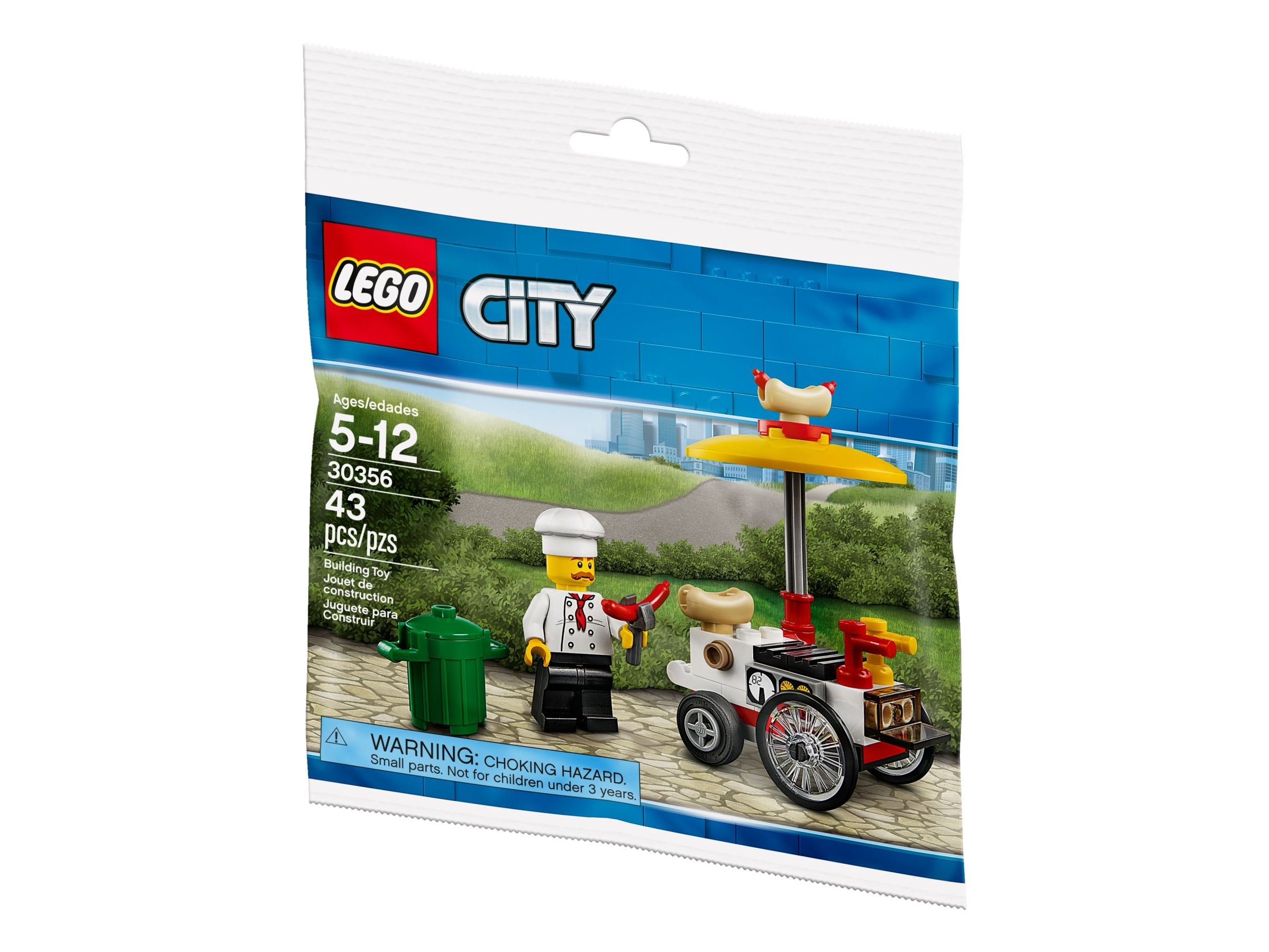 Torba z zestawem LEGO City przedstawia szefa kuchni, wózek z hot dogami i kosz na śmieci. Tło ma niebieską ścianę i zielone liście.