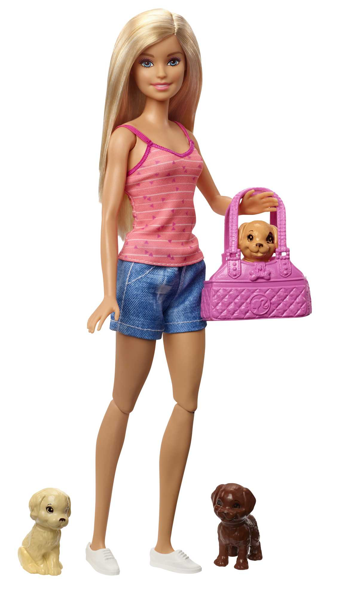 Muñeca Barbie rubia sosteniendo un bolso rosa con un cachorro dentro. Dos cachorros de juguete están a sus pies.