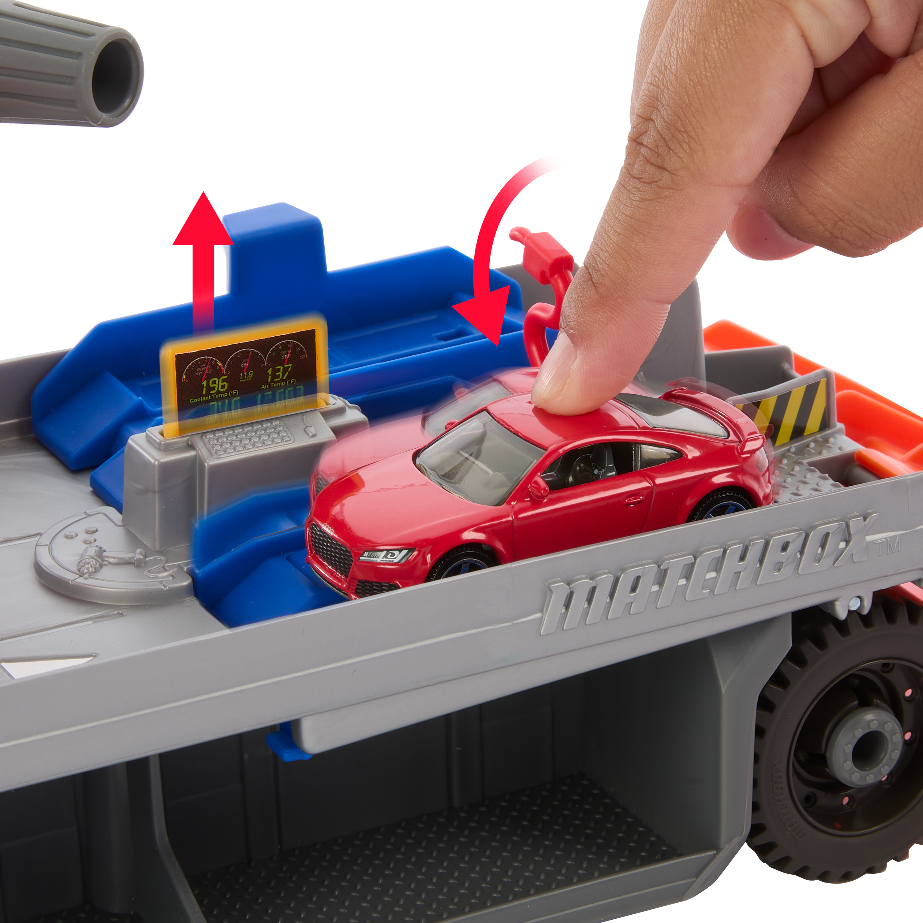 Czerwony samochodzik stoi na ciężarówce Matchbox. Ręka ma zamiar wepchnąć samochód. Ciężarówka ma cyfrowy wyświetlacz.