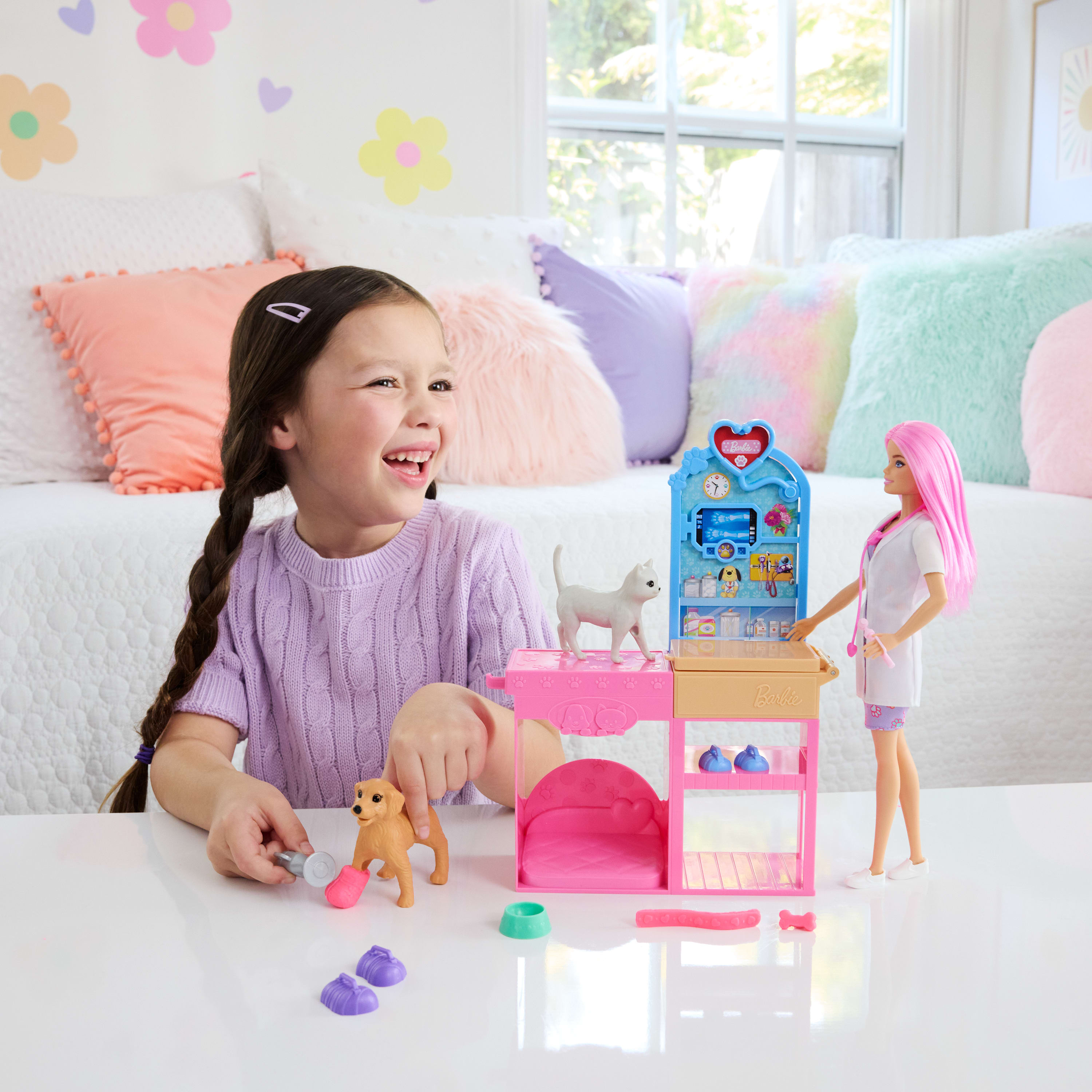 Una niña juega con un set de veterinaria de Barbie. Incluye un perro, un gato, una clínica veterinaria y una muñeca Barbie.