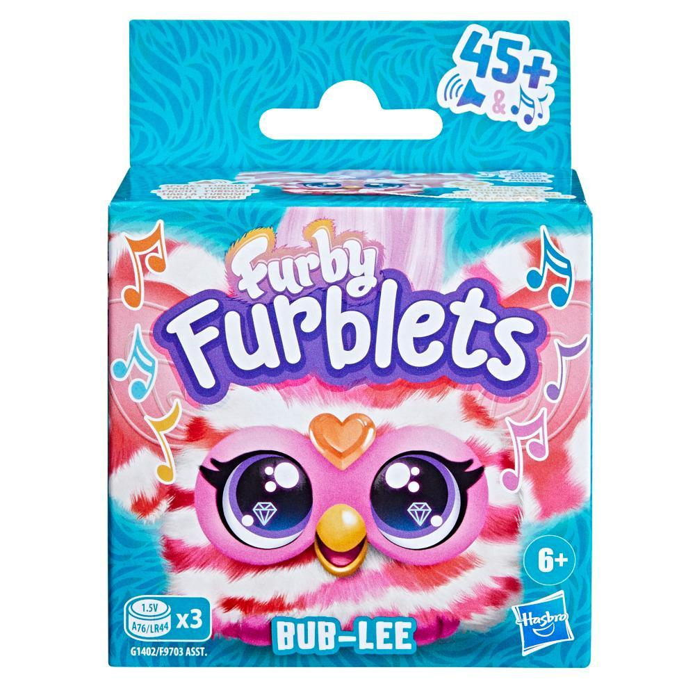 Arte de la caja de un juguete Furby Furblets. Es rosa, blanco y azul, con la cara del juguete en la parte delantera.