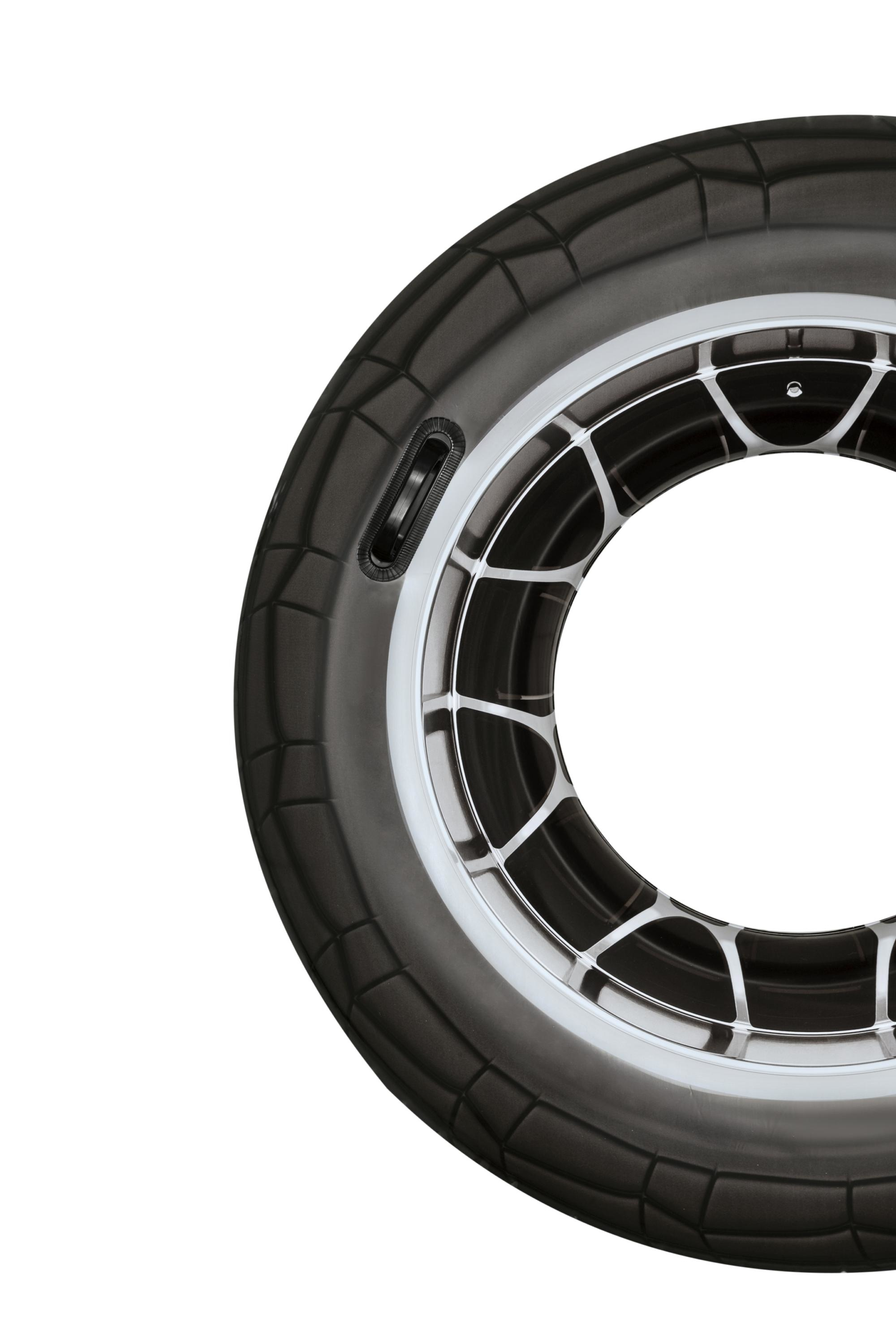 Close-up of a tire, black rubber with a silver rim, and a white background.