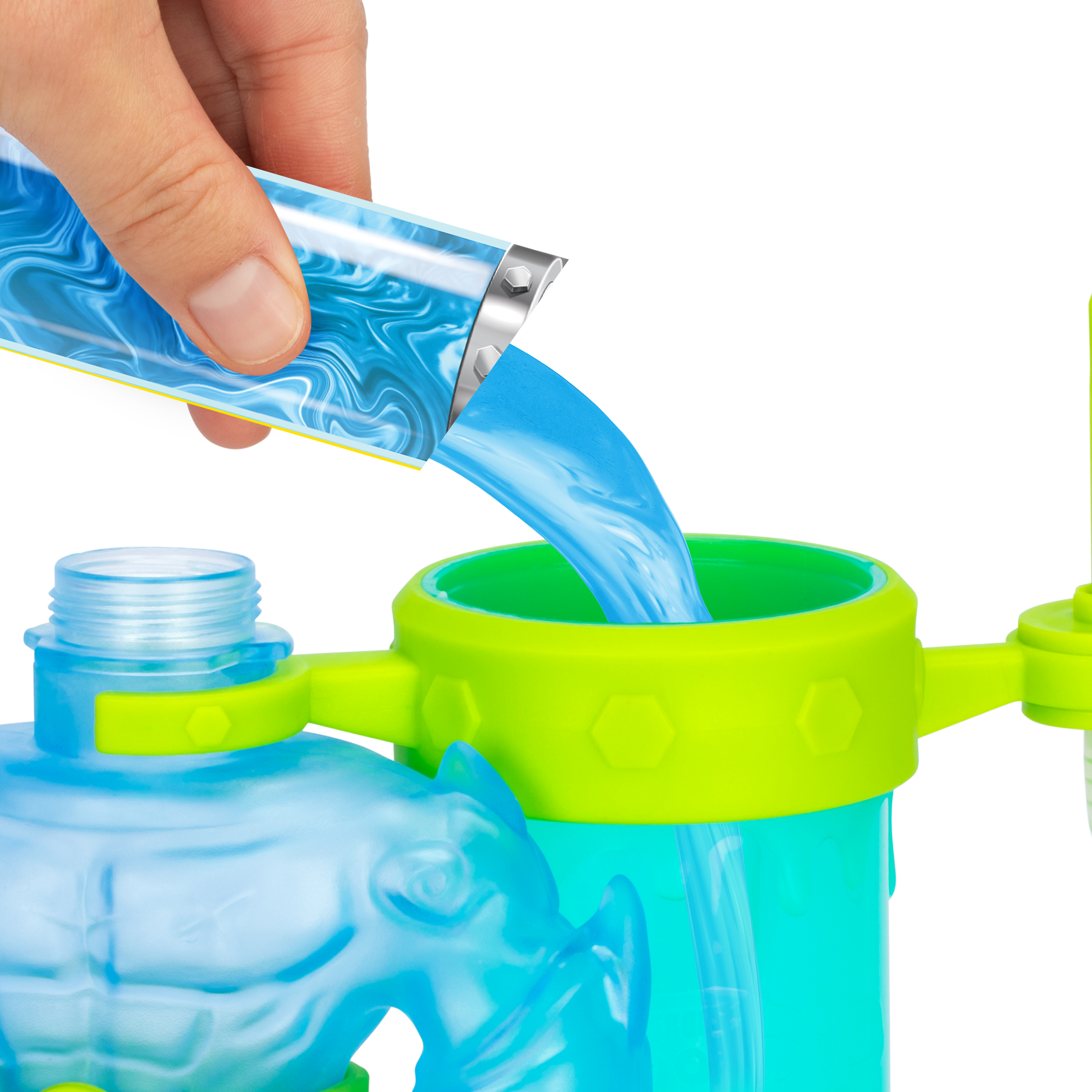 Eine Hand gießt blaue Flüssigkeit aus einem Behälter in ein grün-blaues Kunststoffspielzeug, weißer Hintergrund.