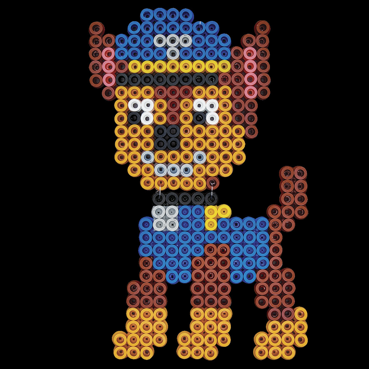 Een kleurrijke hond gemaakt van kleine cirkels, met een blauwe muts en uniform. Het is een stripfiguur met bruine, gele en blauwe kleuren.